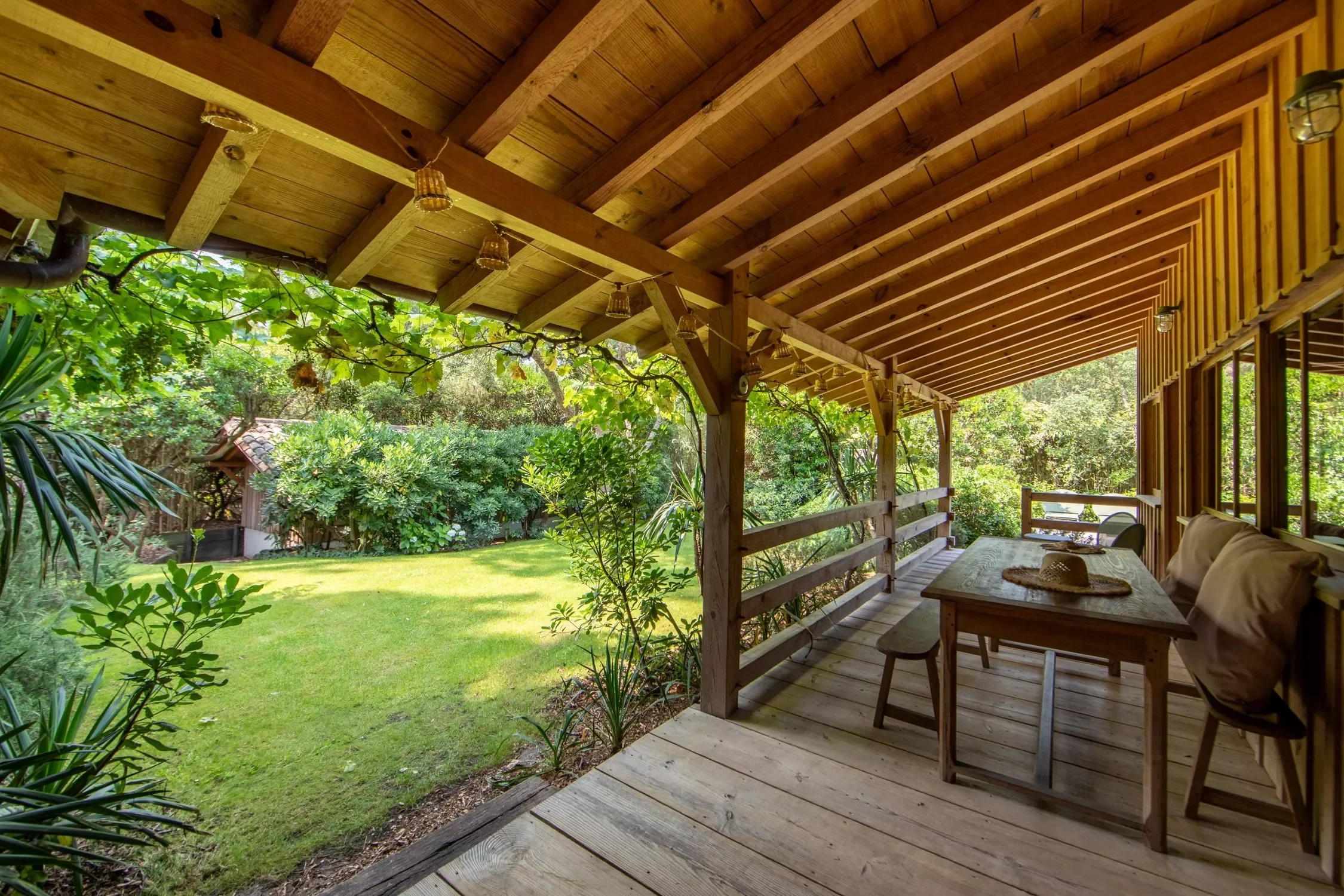 Terrasse en bois avec mobilier et vue sur jardin verdoyant