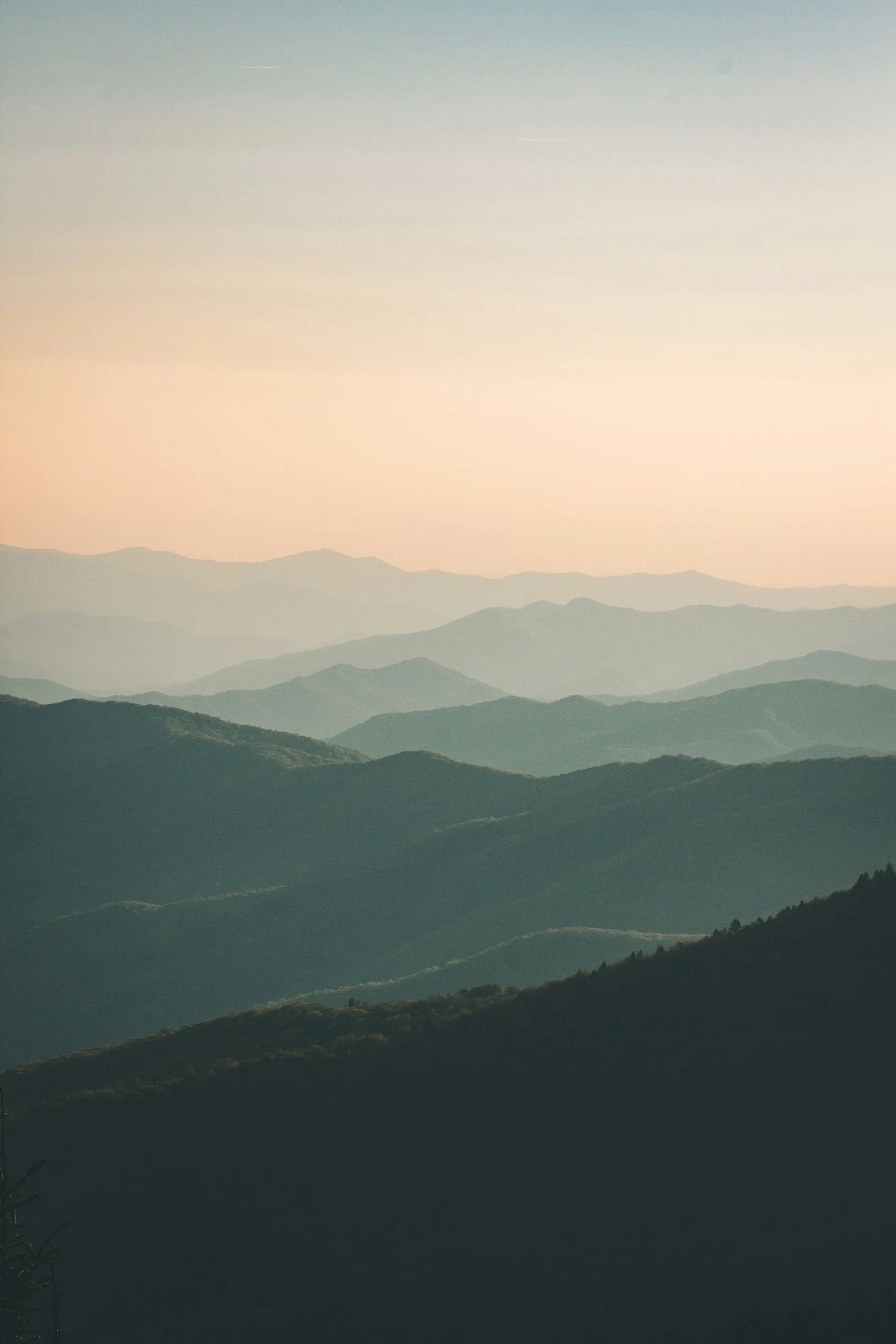 Weite Berglandschaft mit sanften Hügeln im Morgenlicht.