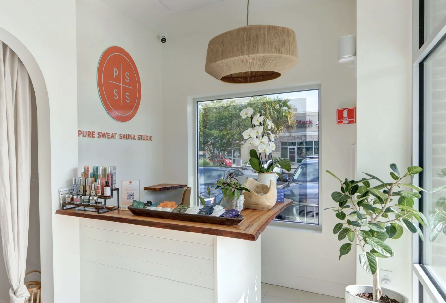 A gloved hand holding a test tube filled with blood, with other test tubes containing blood samples organized in a rack nearby in a laboratory setting.