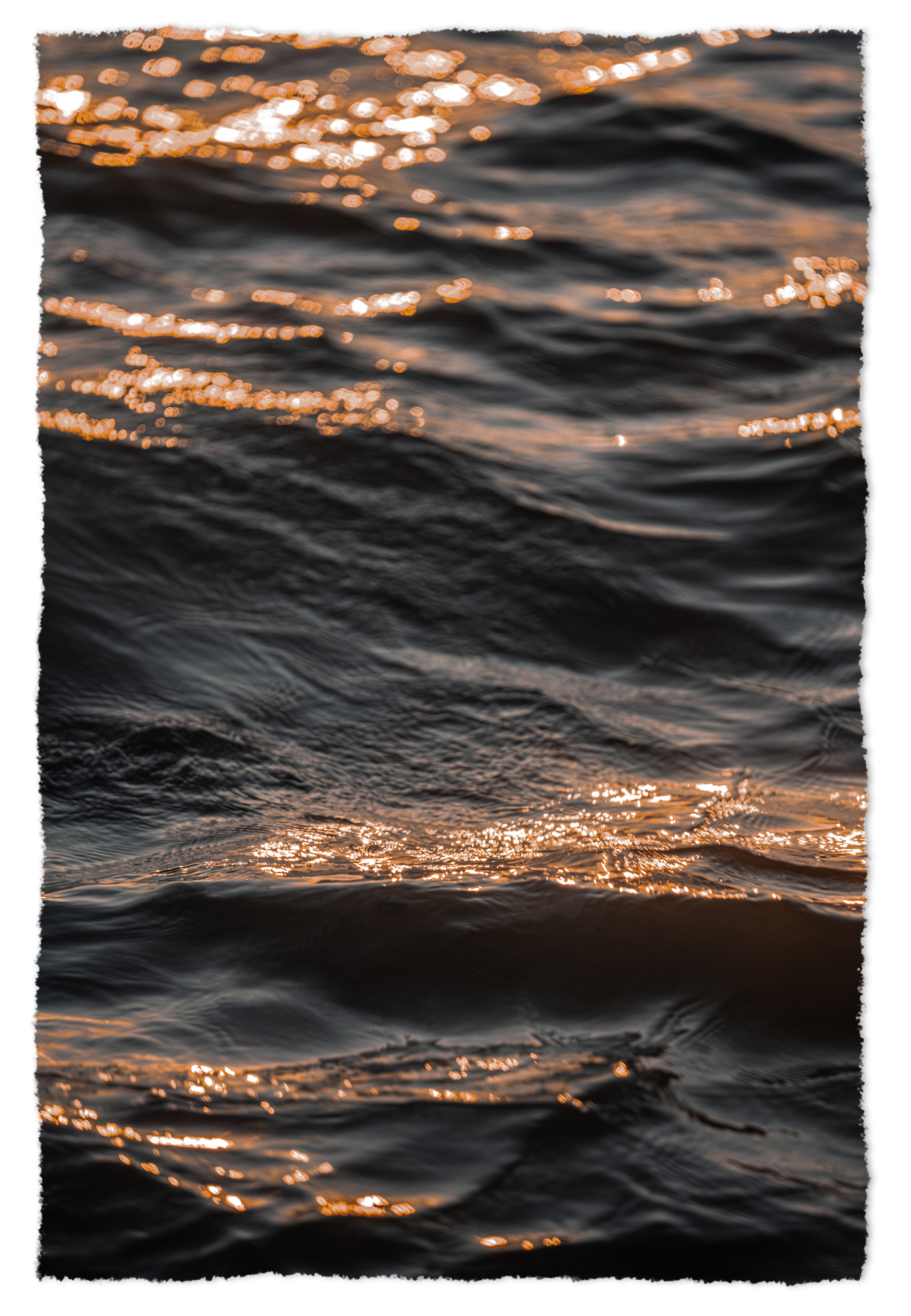 Close-up of water with small waves and sunlight reflecting off the surface at sunset.