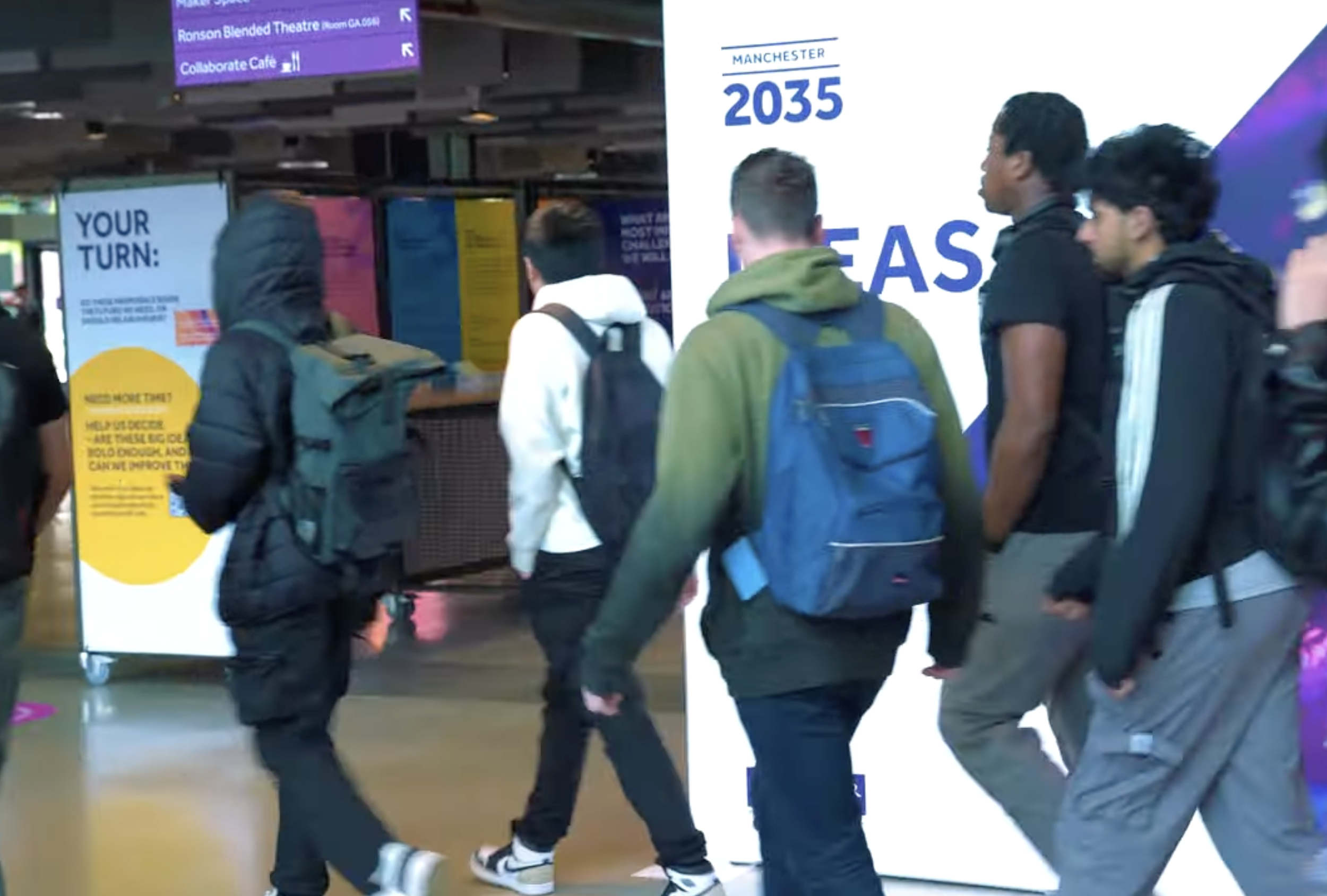 A photo of a lively strategy exhibition with students walking past 