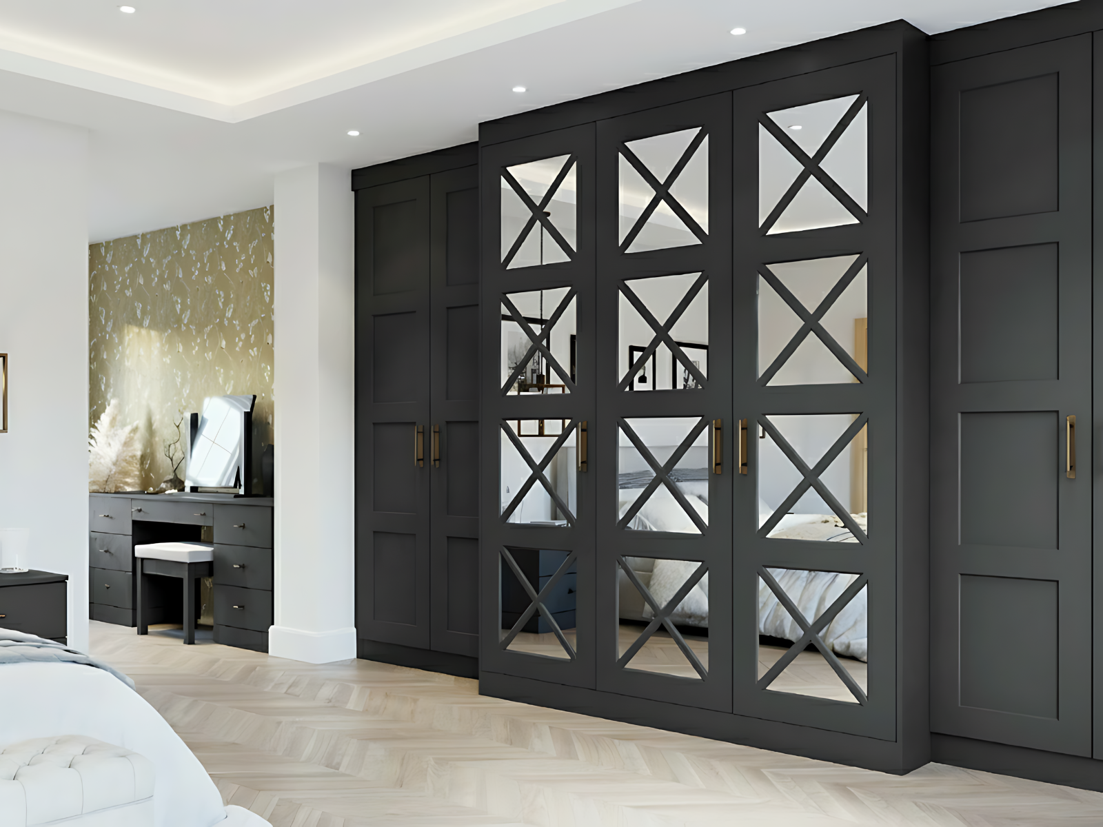 Modern bedroom with large black wardrobe with mirrored and cross-pane doors, a black vanity with a mirror, a gold accent wall, and light-colored herringbone wood flooring.