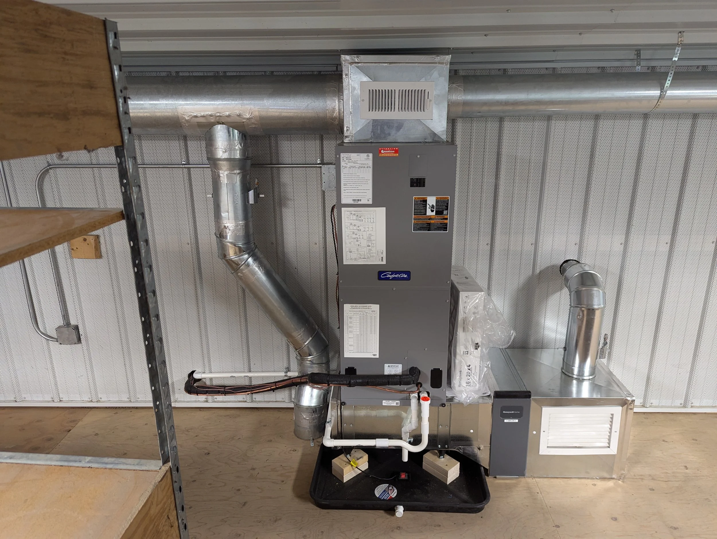 HVAC furnace system with ducts and vents in a utility room.