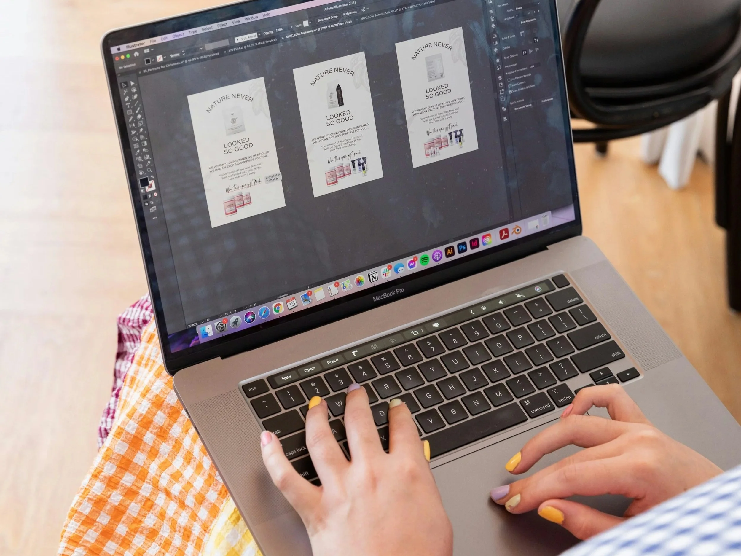 woman with laptop on lap and painted yellow and purple nails using a photo editing software to create marketing materials for her product business