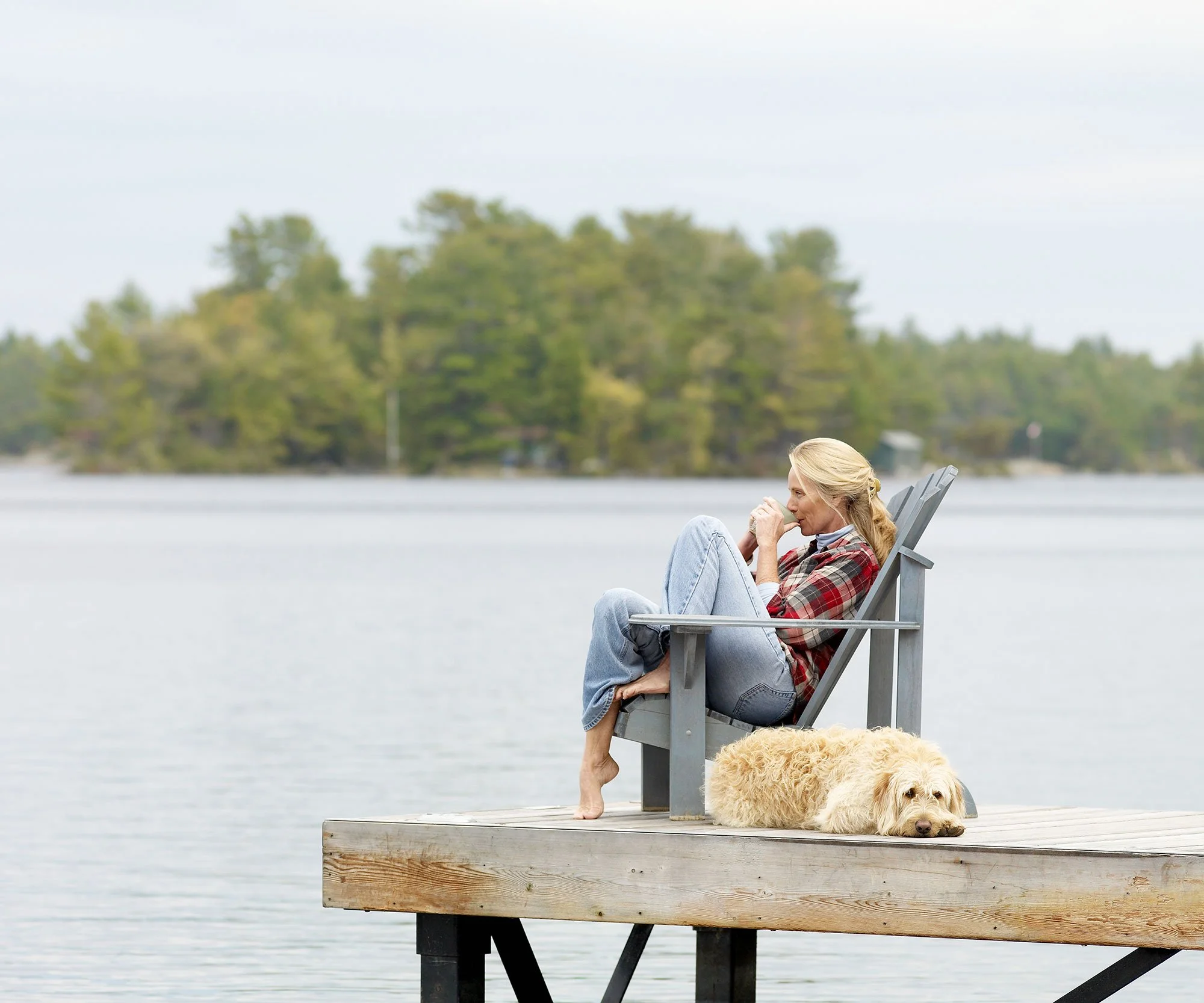 lady-on-dock-enjoying-coffee-with-her-dog.jpg