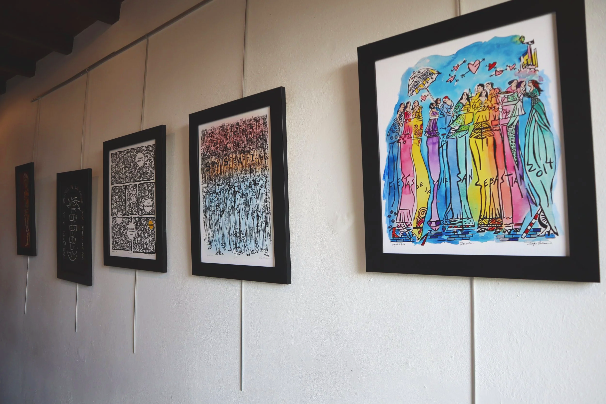 Colorful artwork depicting a group of women standing together, with the words "Fiesta San Sebastian 2014" written on the bottom.