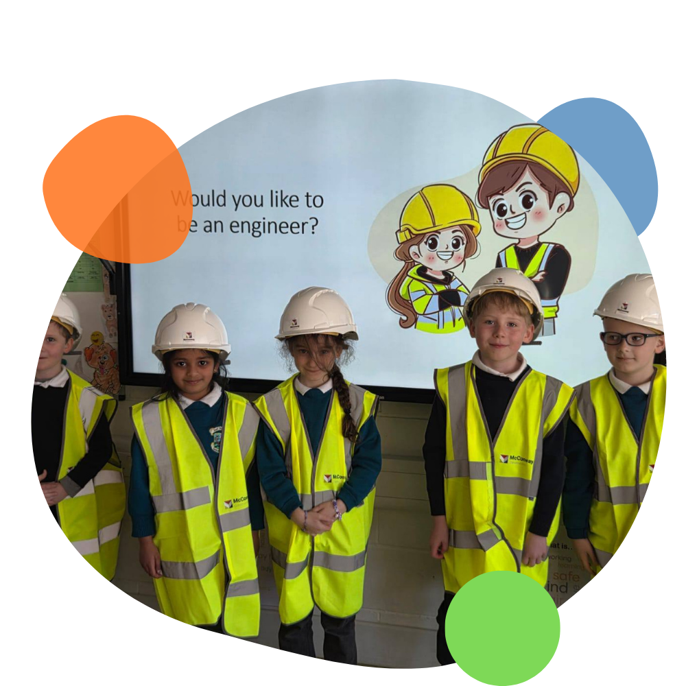 Group of children in high visibility jackets and white hard hats standing in front of a presentation screen with cartoon construction characters and the question 'Would you like to be an engineer?'