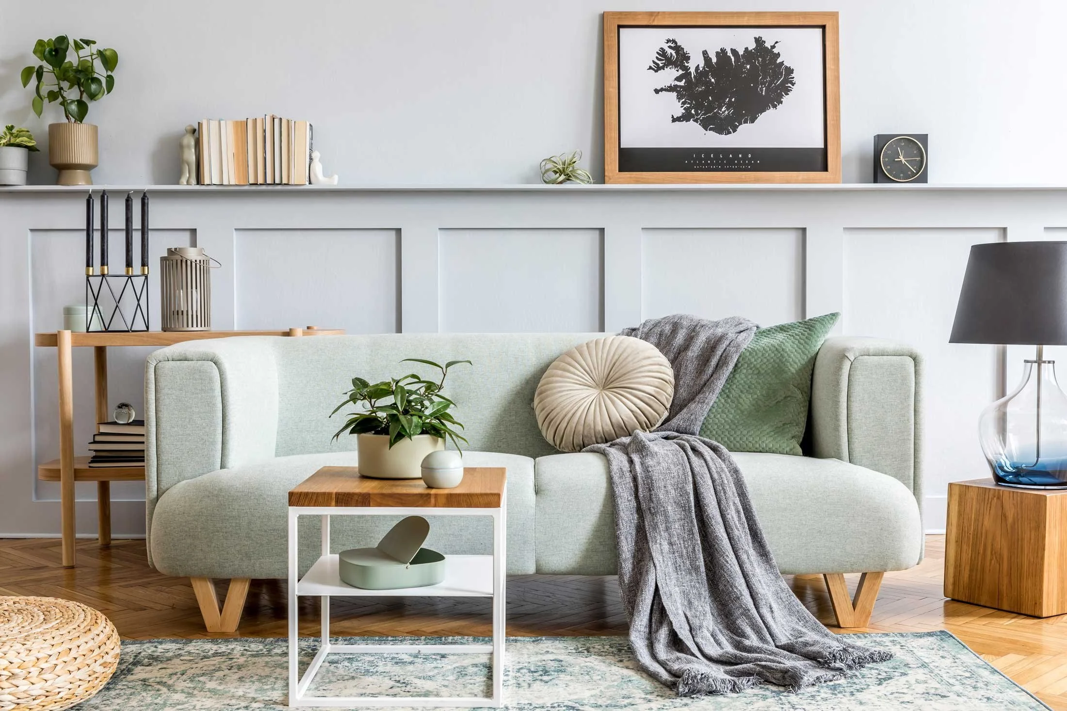 Professionally styled vacation rental living room with light gray sofa, decorative pillows, throw blanket, and curated decor after Airbnb turnover cleaning in Phoenix