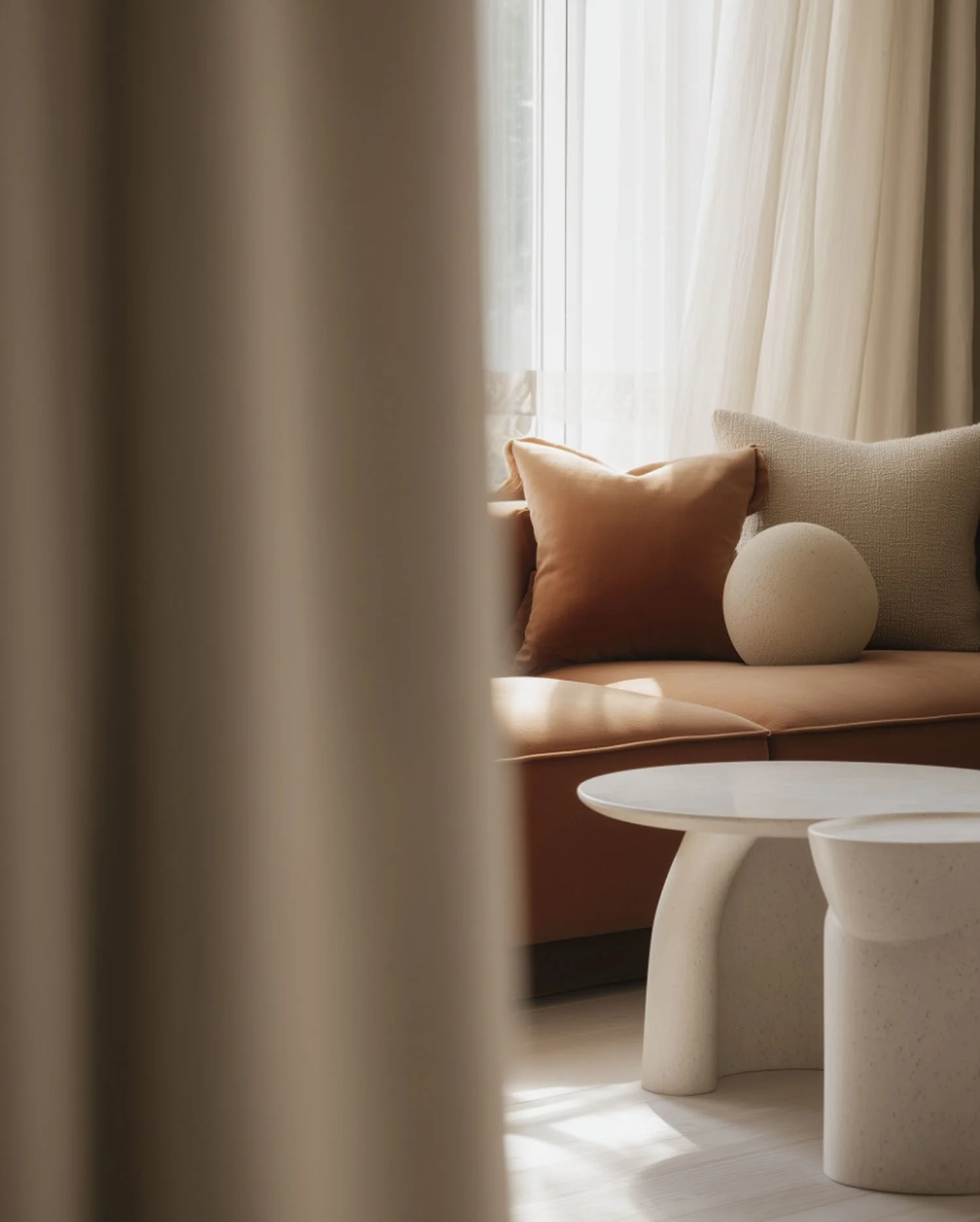 Cozy residential living room corner with earth-tone pillows on beige sofa and clean white side table, showcasing home cleaning services in Tempe and Mesa
