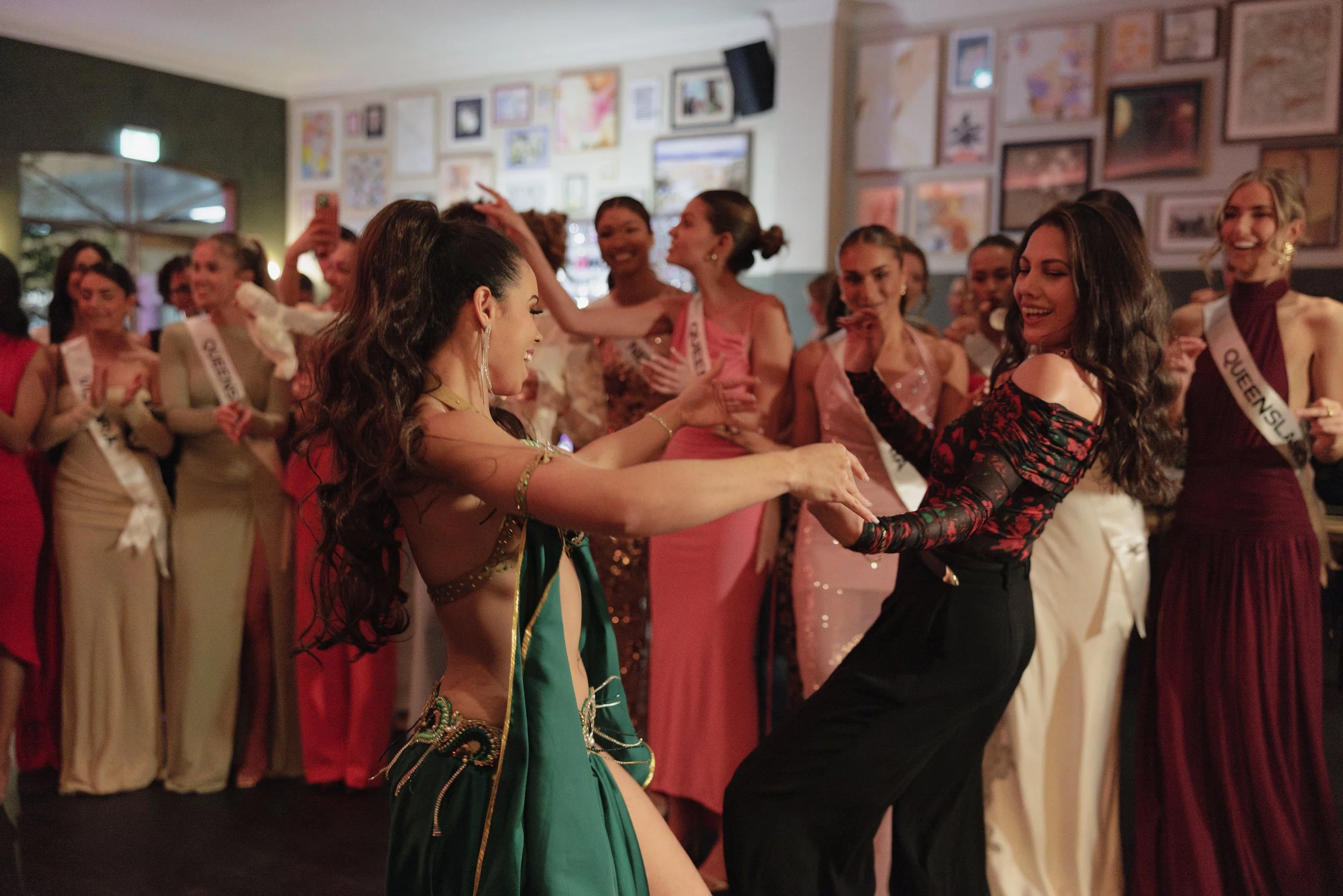 a belly dancer smiling and dancing with a audience member during a dance entertainment show