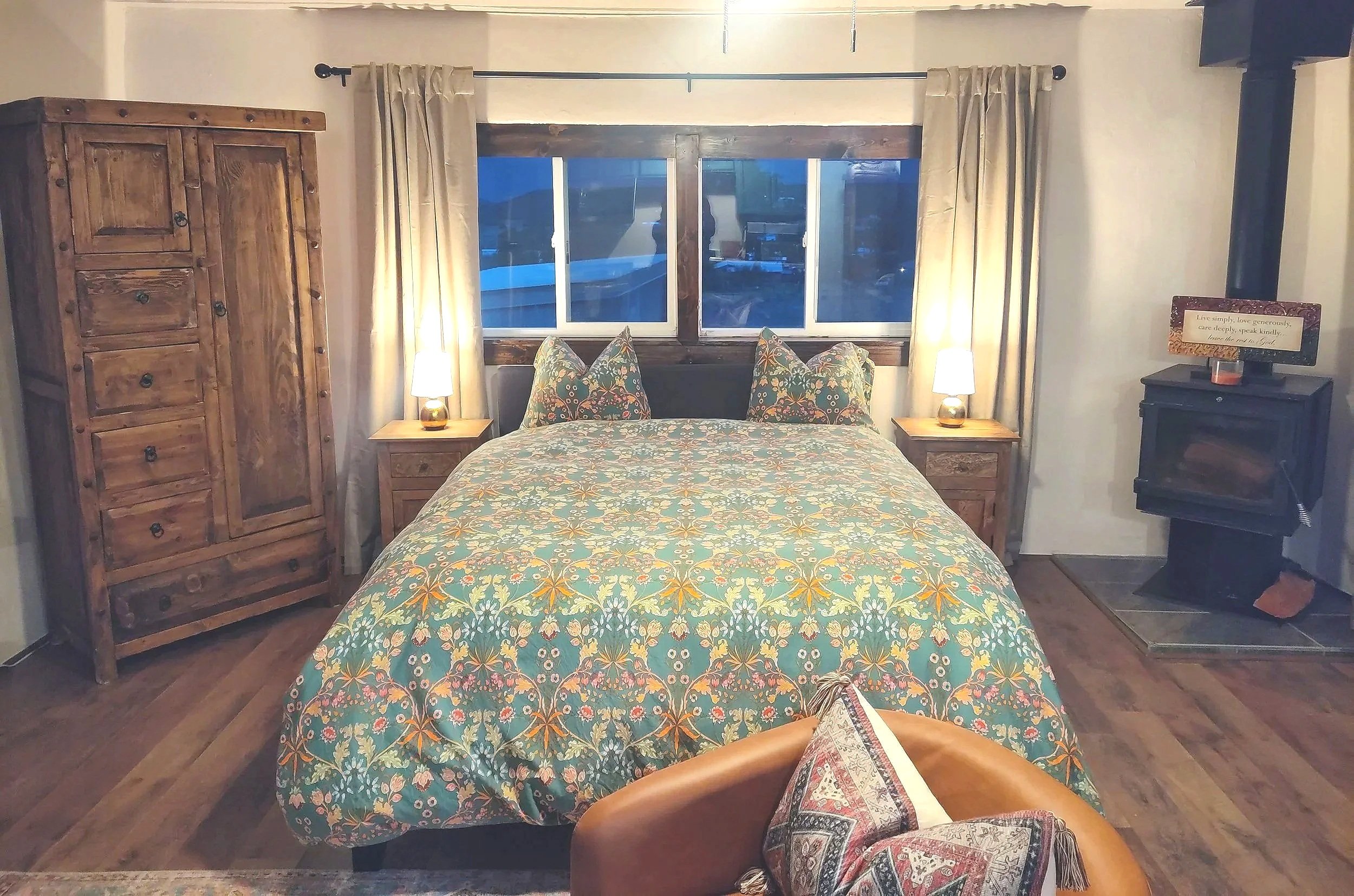 A cozy bed inside an adobe studio casita in a village along the High Road to Taos