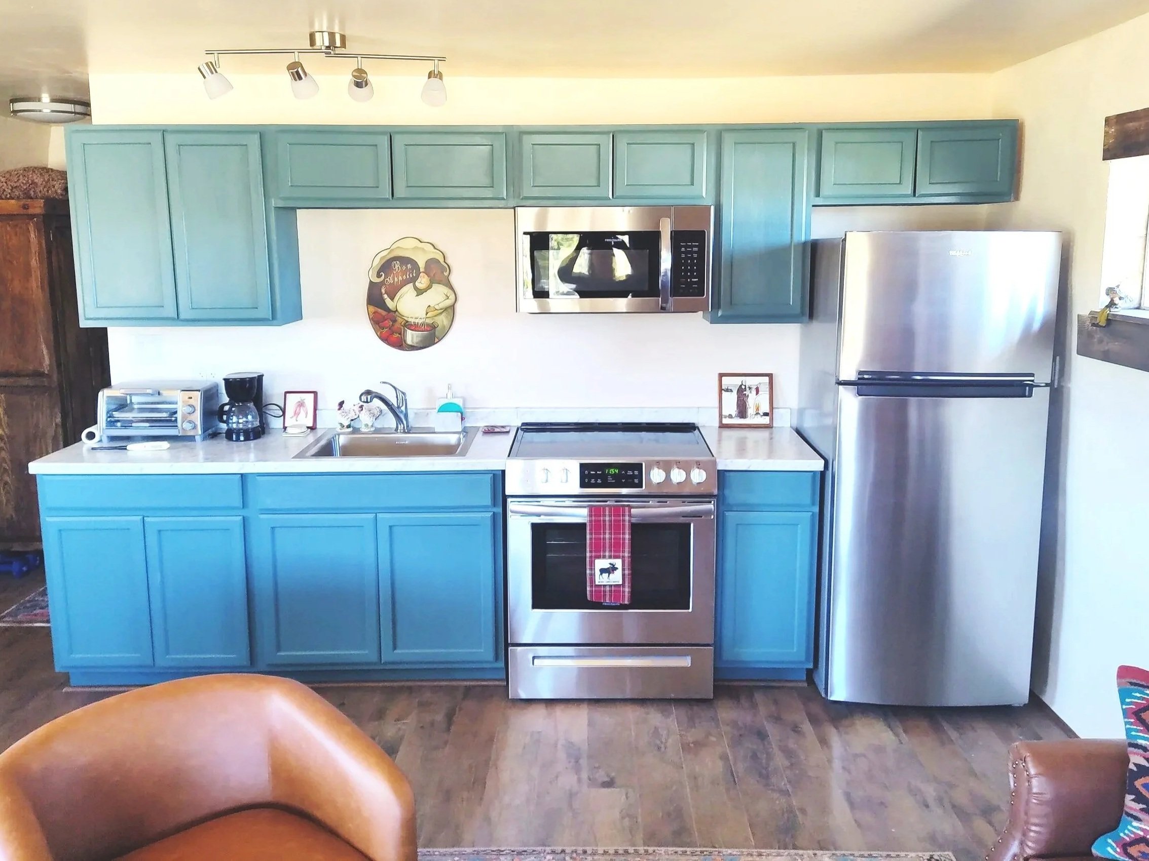 A blue kitchen featured in an adobe studio casita in a village along the High Road to Taos