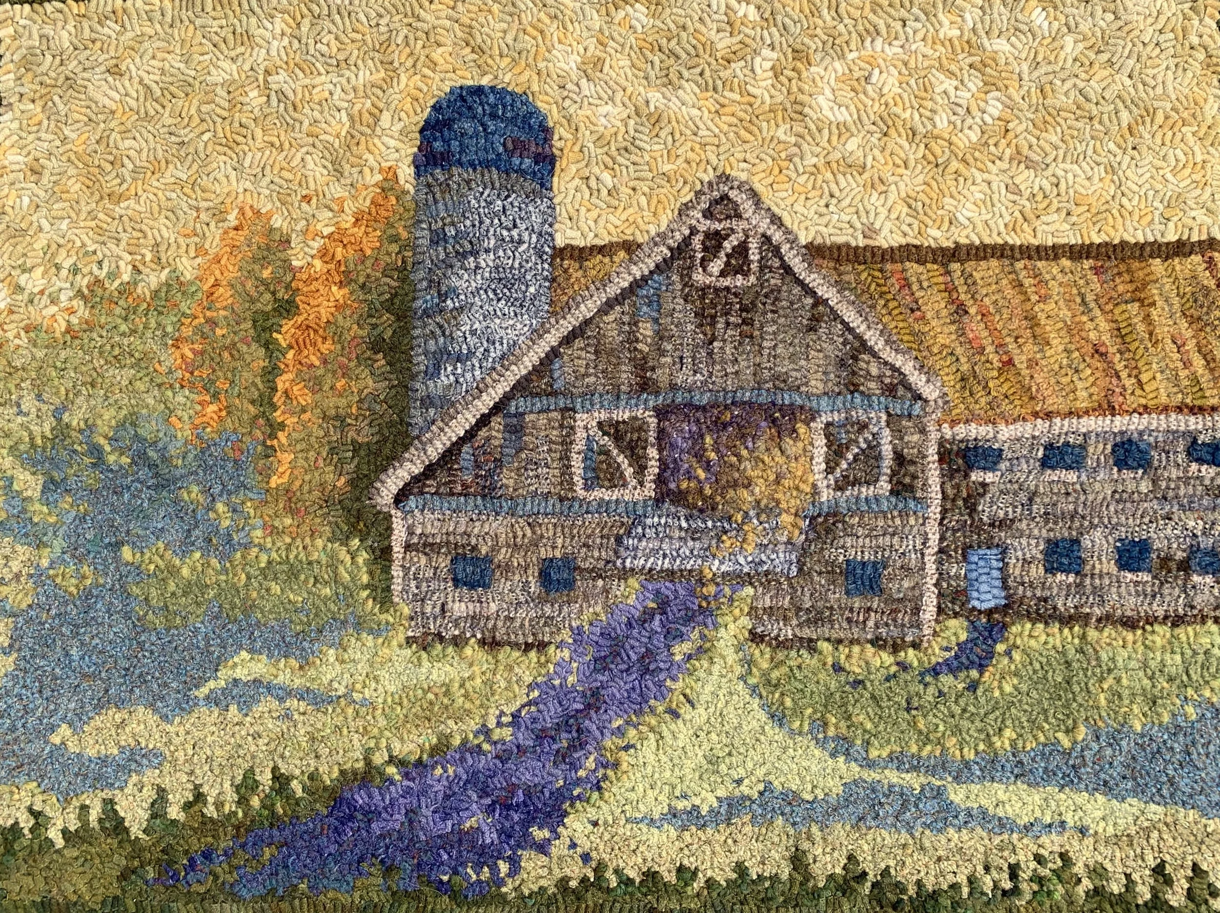Colorful rug depicting a barn with a silo, trees, a path, and rolling hills.
