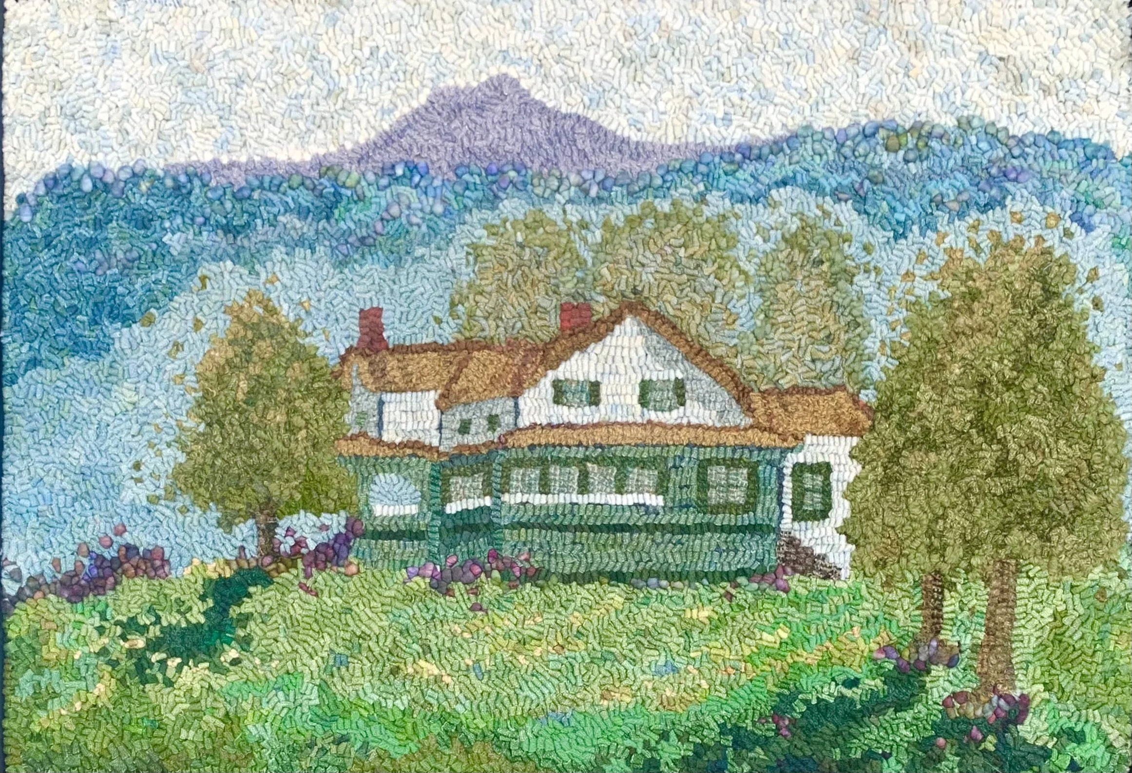 A colorful mosaic of a house surrounded by trees, with mountains in the background and a grassy landscape in the foreground.