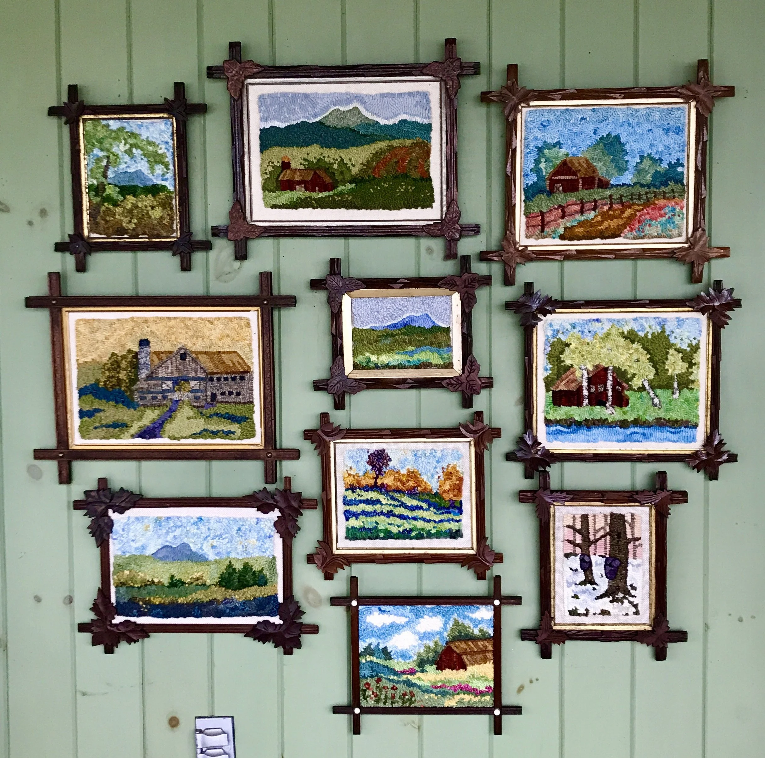 Collection of ten framed hooked landscape scenes, featuring mountains, trees, houses, rivers, and fields.