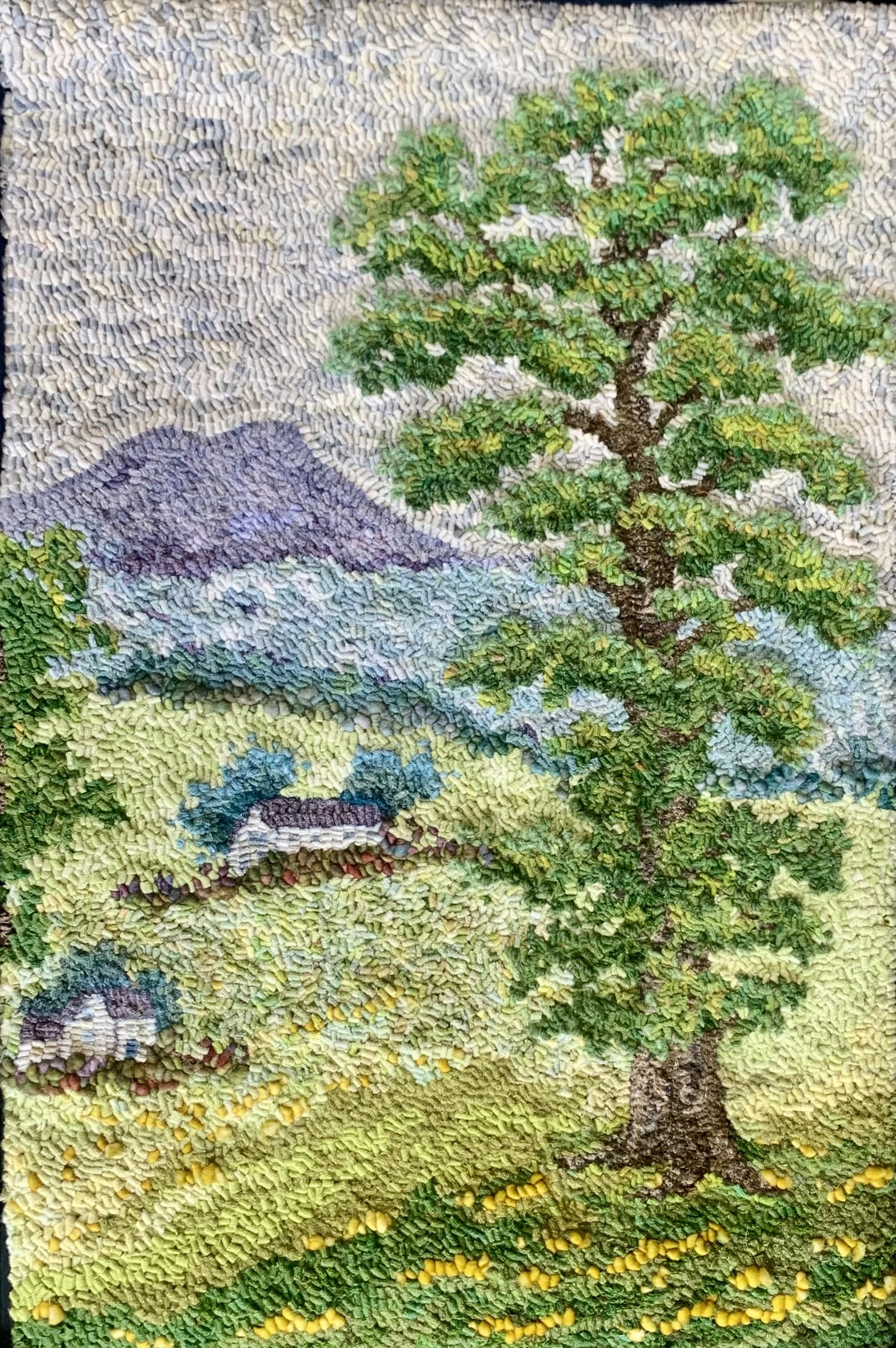 A colorful landscape mosaic with a mountain, trees, houses, and grassy field.