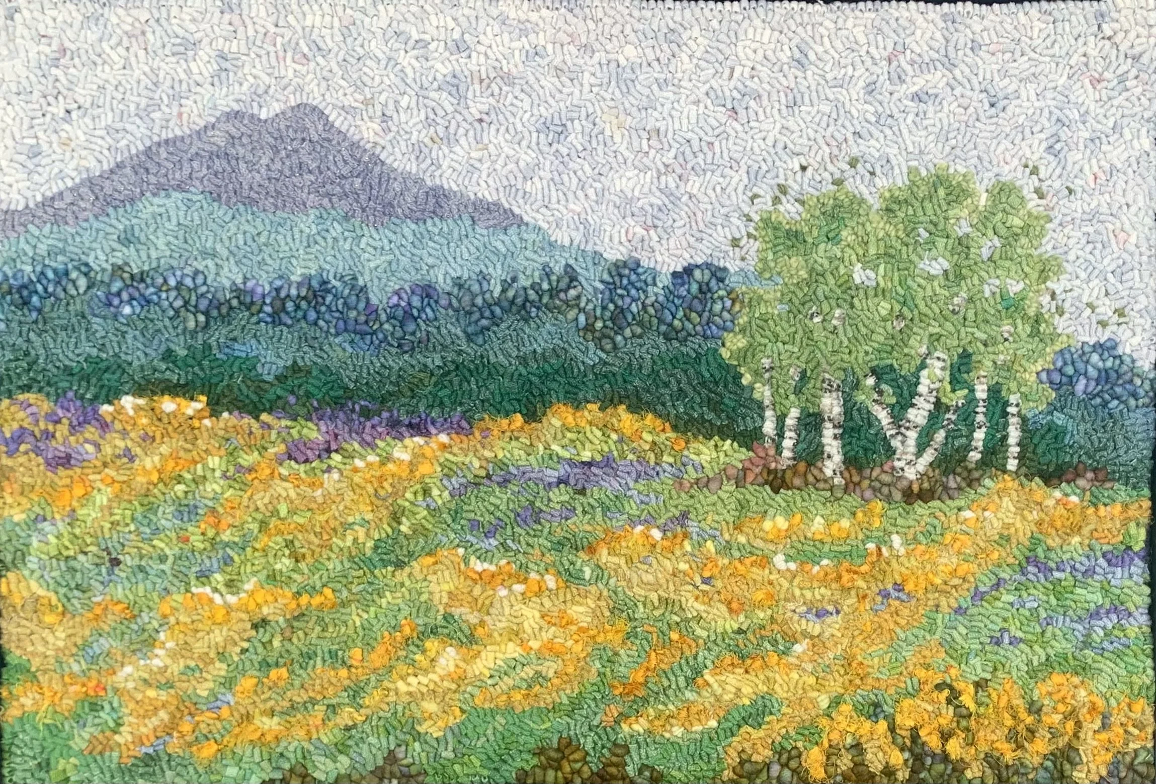 A colorful mosaic depicting a landscape with a mountain in the distance, green trees, and a field of yellow flowers in the foreground.