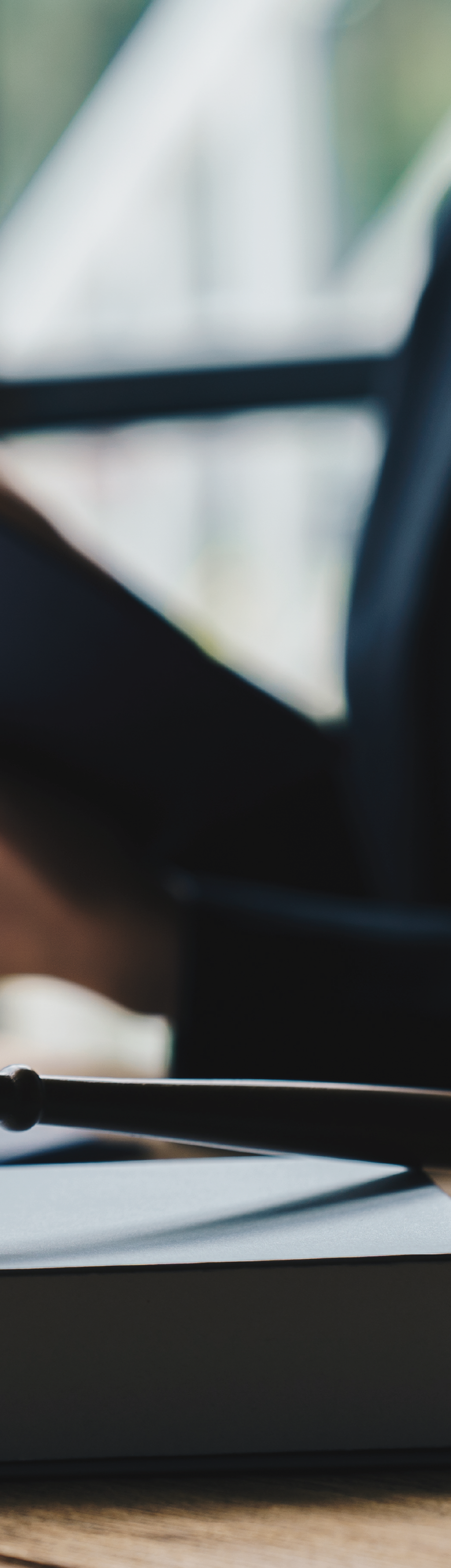 Imagen de un violín y una partitura en una mesa, con bicicleta en el fondo.