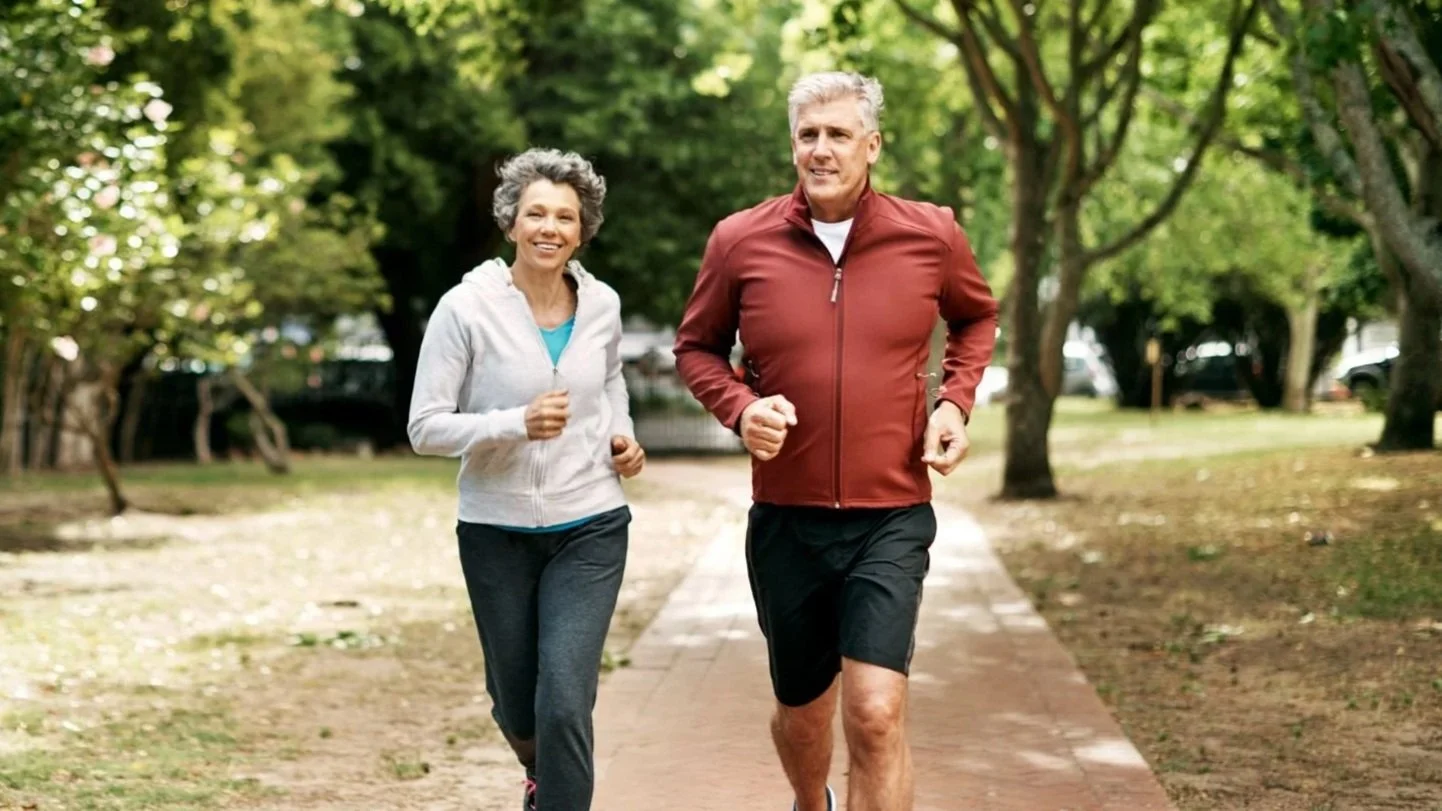 Older couple man and woman jogging in a park