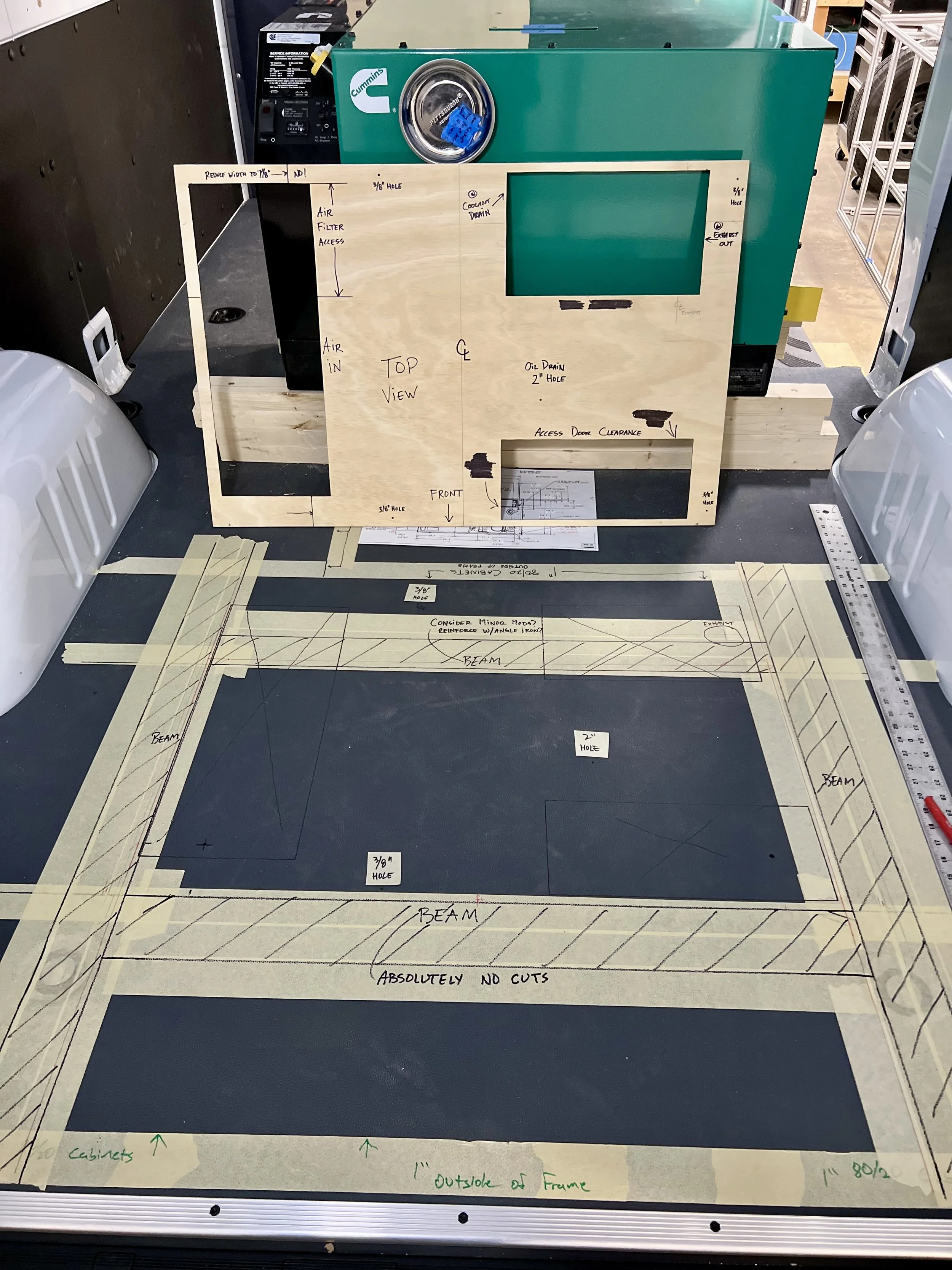 A woodworking project plan with a wooden board and a paper blueprint having measurements and notes, situated on a workbench in a workshop. The plan includes cuts for a top view and front view with various labeled holes, openings, and beam placements.