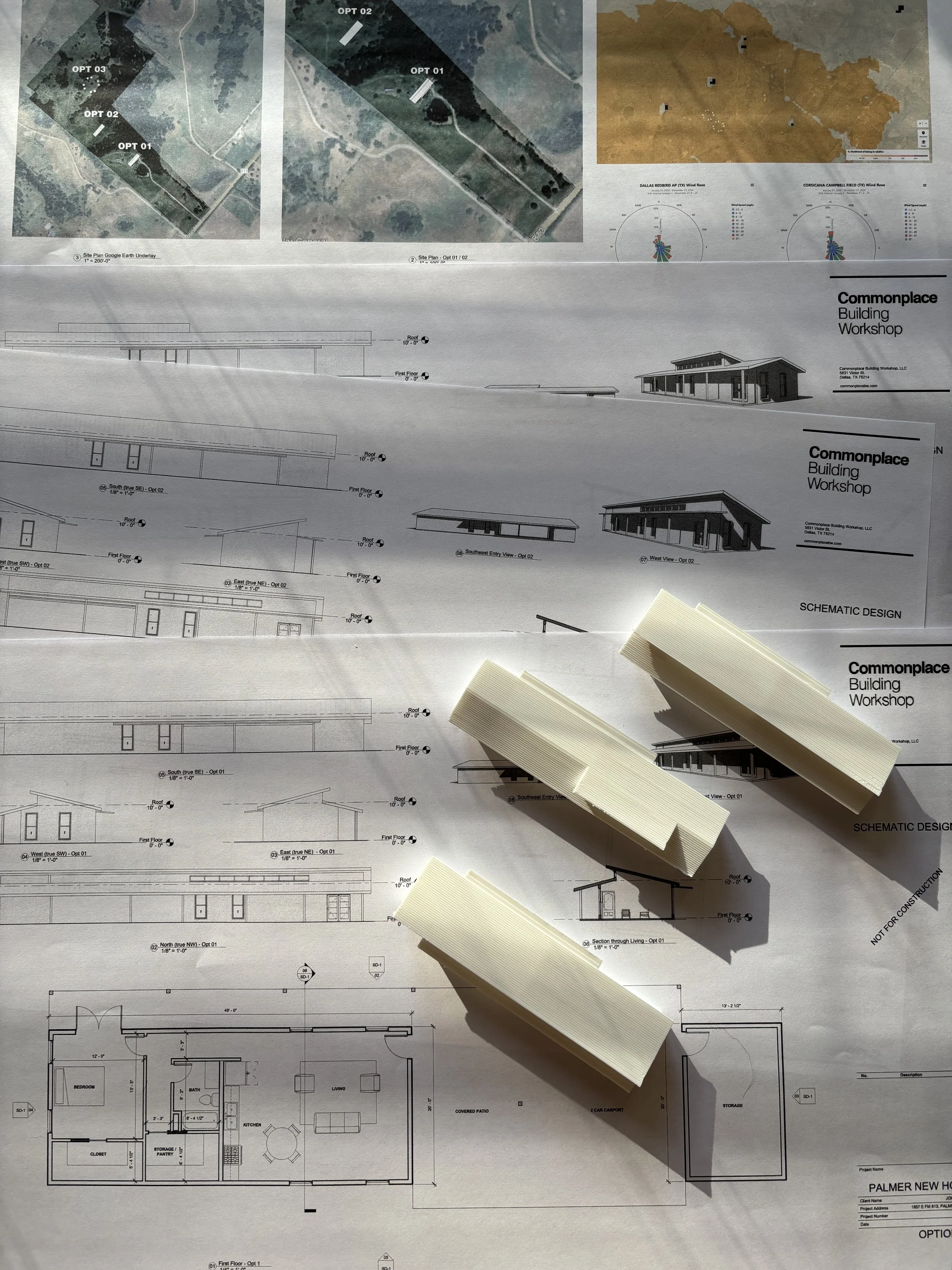 Blueprint and schematic design plans for a modern building workshop with model structures on top, along with site maps of plot options and topographical features.