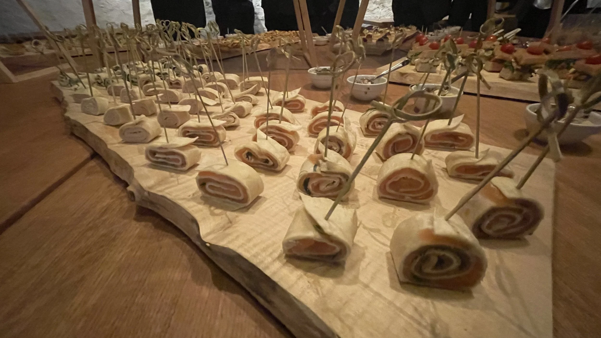 Kleine Wraps mit Schinken und Käse auf Holzbrett