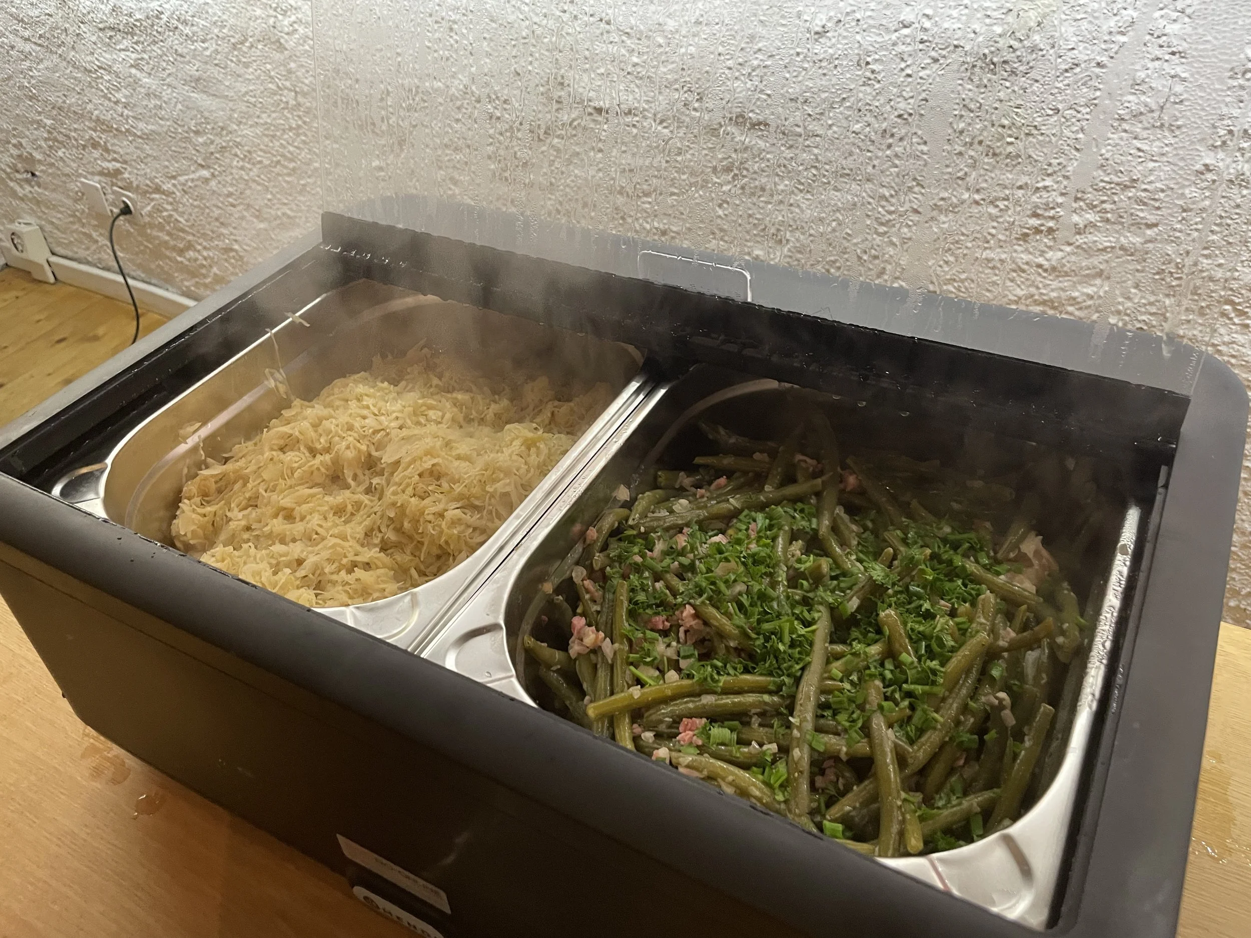 Buffet mit gedünstetem Sauerkraut und grünen Bohnen mit Speck.