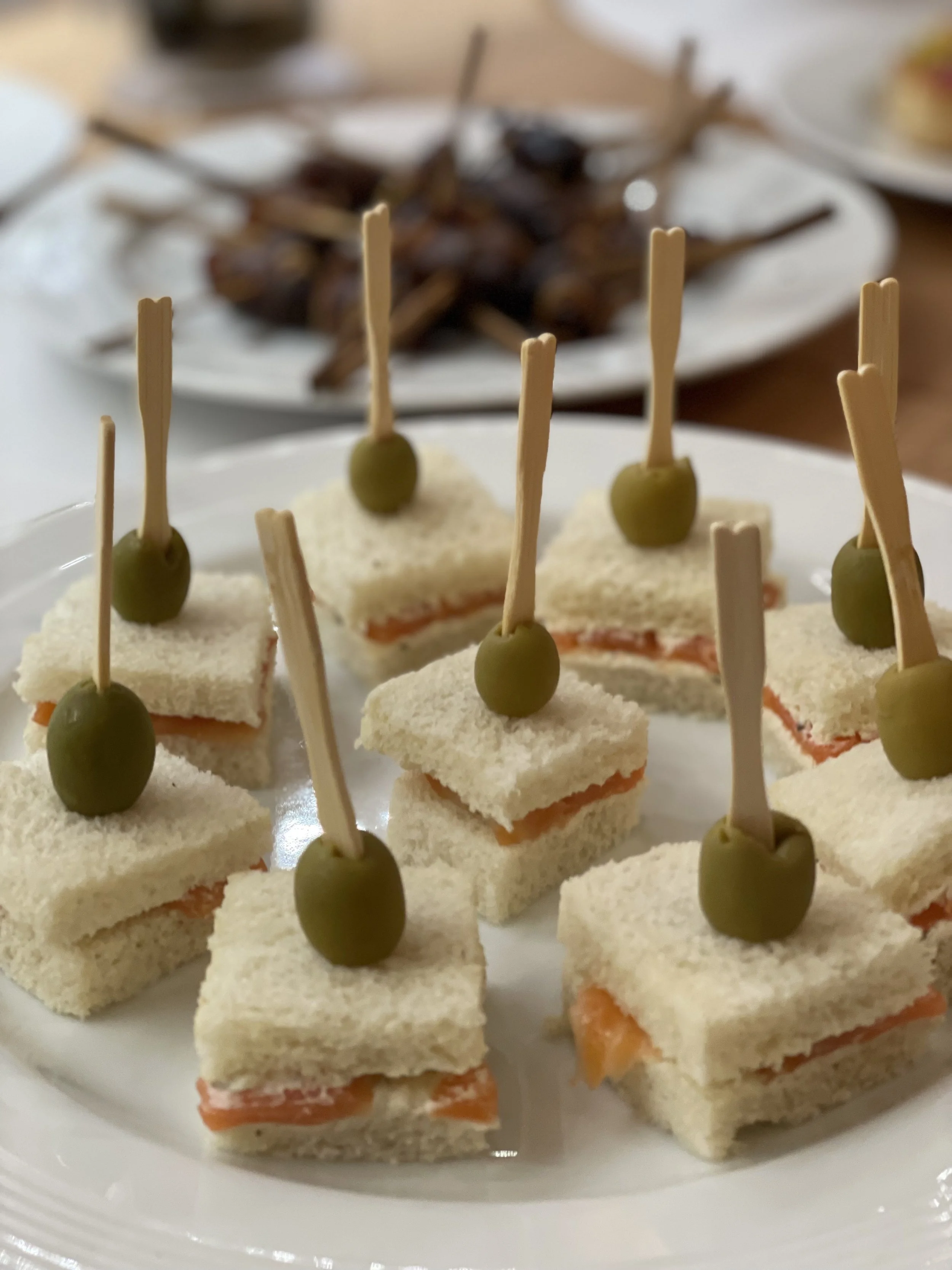 Mini Sandwiches mit Lachs, garniert mit grünen Oliven