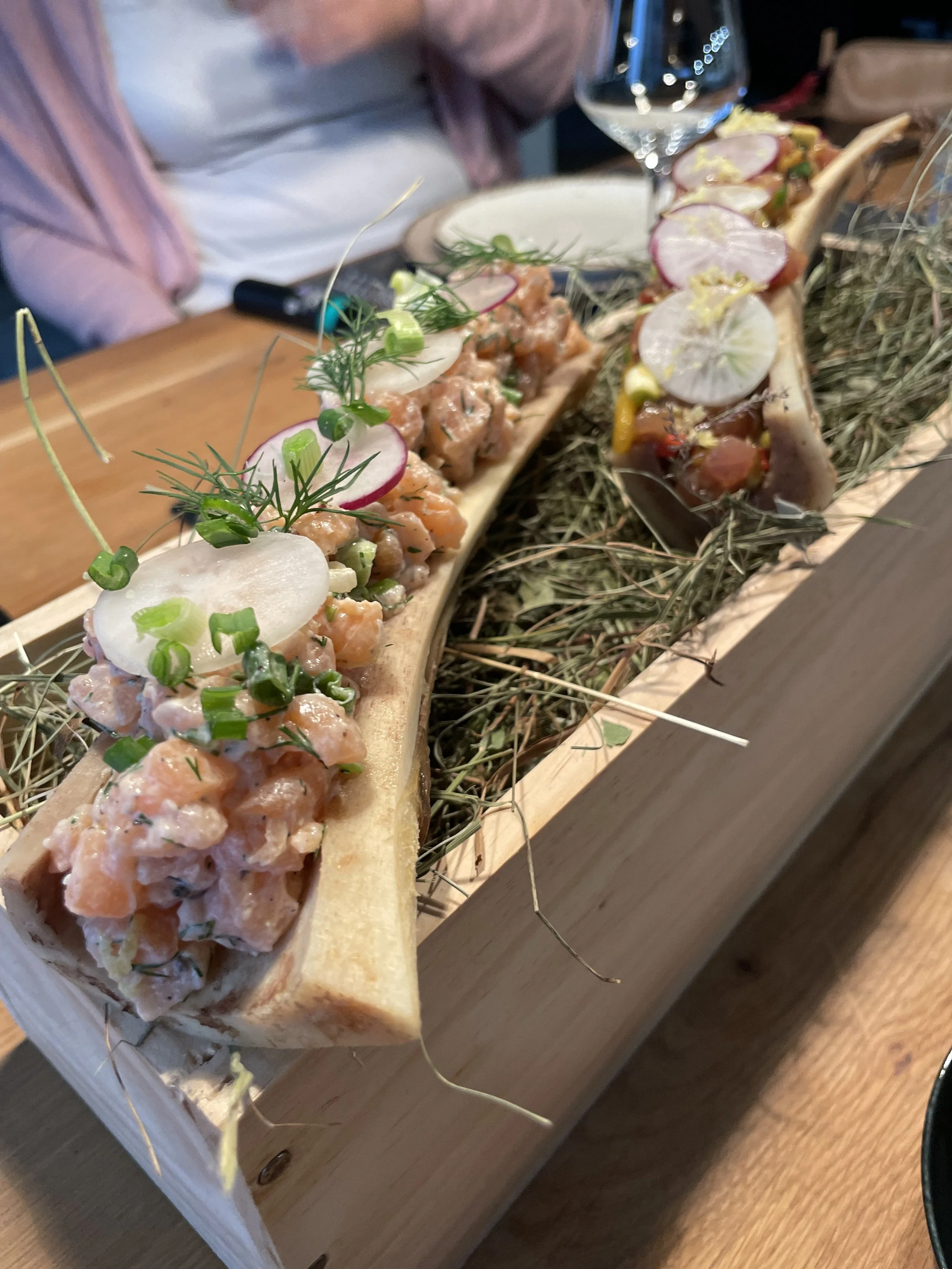 Rindstartar in einem Marktknochen, dekoriert mit Radieschen, Frühlingszwiebeln und frischen Grün, serviert in an einem privaten Catering-Anlass in der Zentralschweiz.