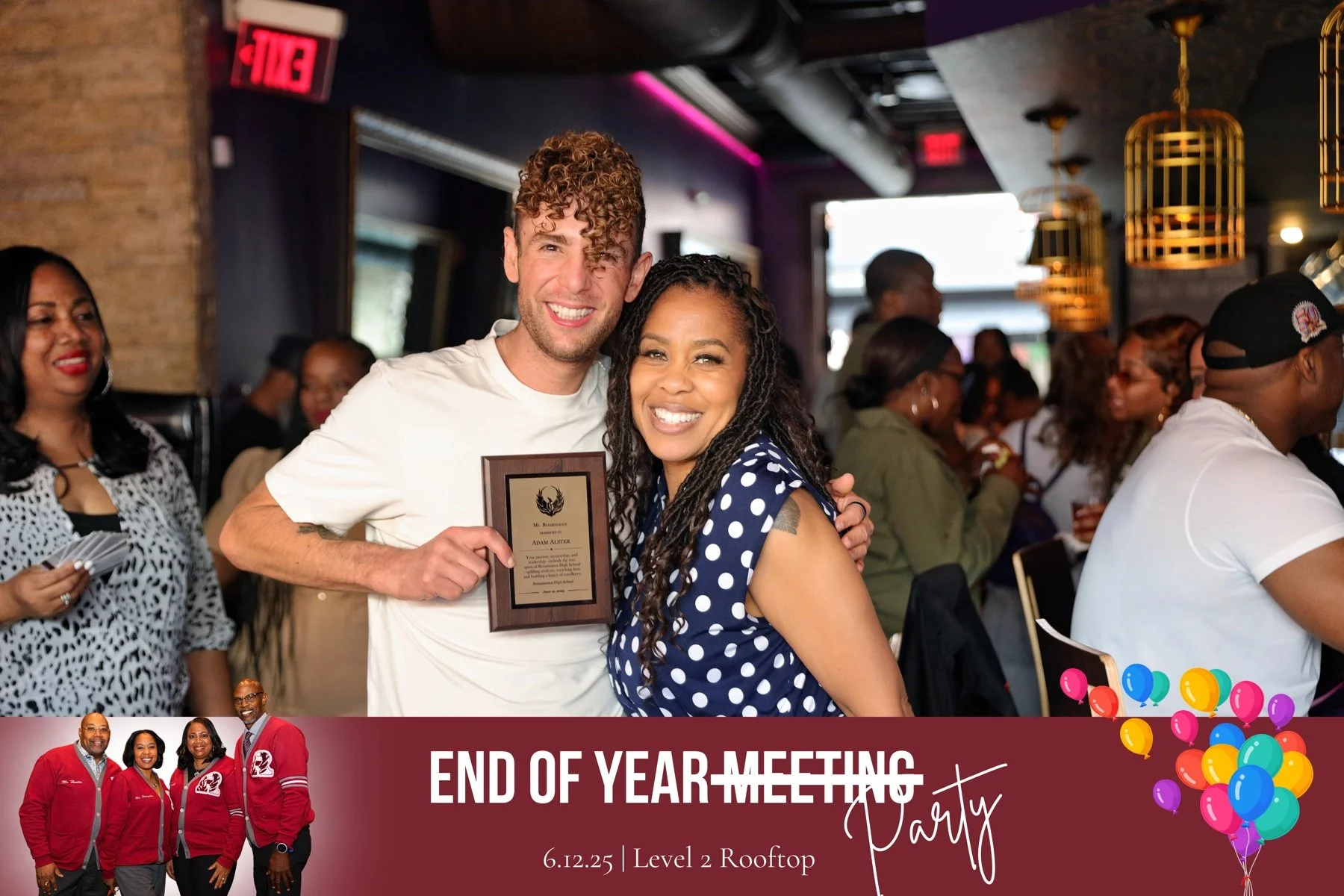 A man and woman are smiling and hugging at a celebration event. The man is holding a plaque. In the background, there are other people at tables, and decorative lighting. The event banner says 'End of Year Meeting Party, 6.12.25, Level 2 Rooftop' with colorful balloons.