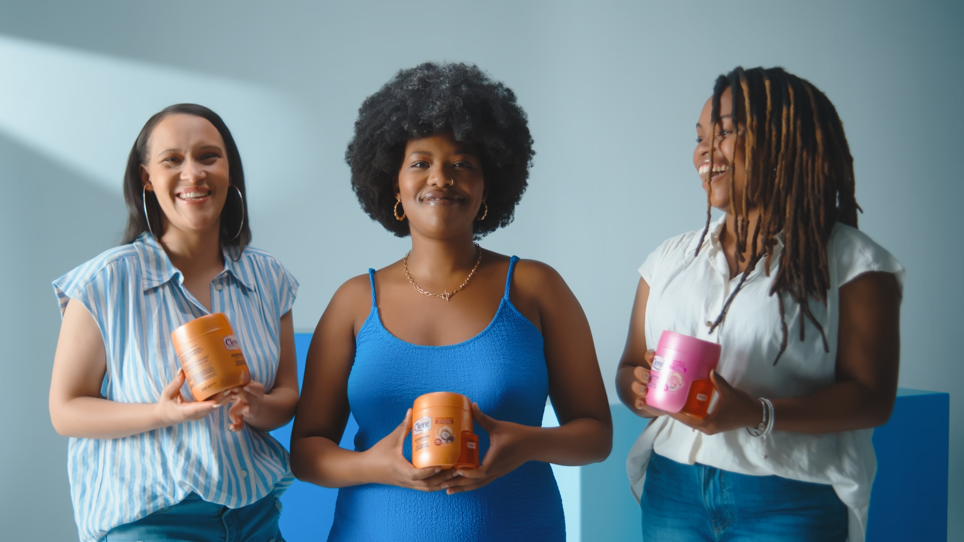 A modern wooden building with large glass window in a mountainous landscape with grassy foreground.