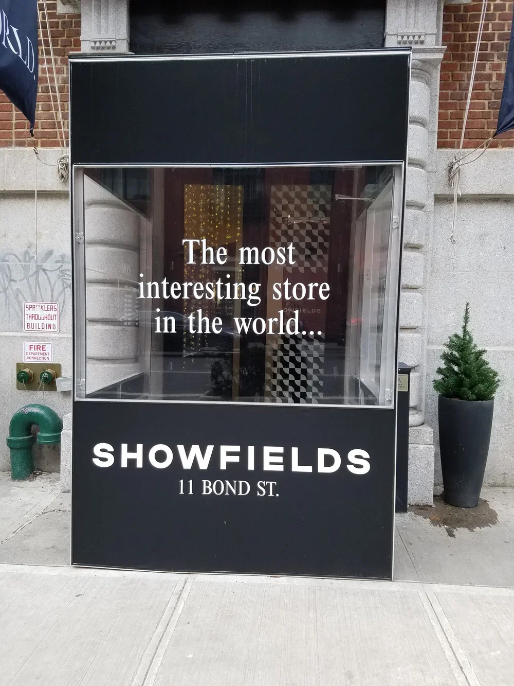 A storefront sign outside Showfields on Bond Street with the text "The most interesting store in the world..." and the address 11 Bond St., in New York City.