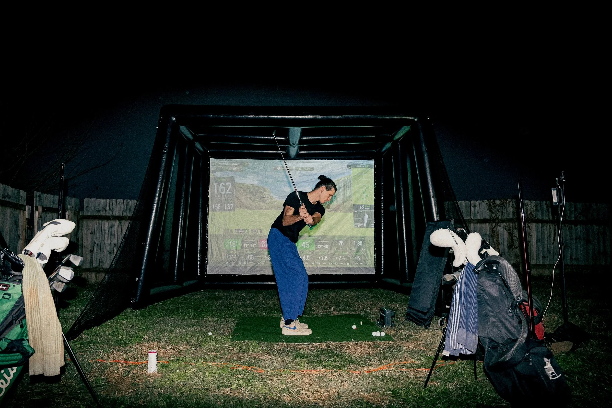 Golf simulator experience in Nashville with a player practicing on a digital indoor setup.