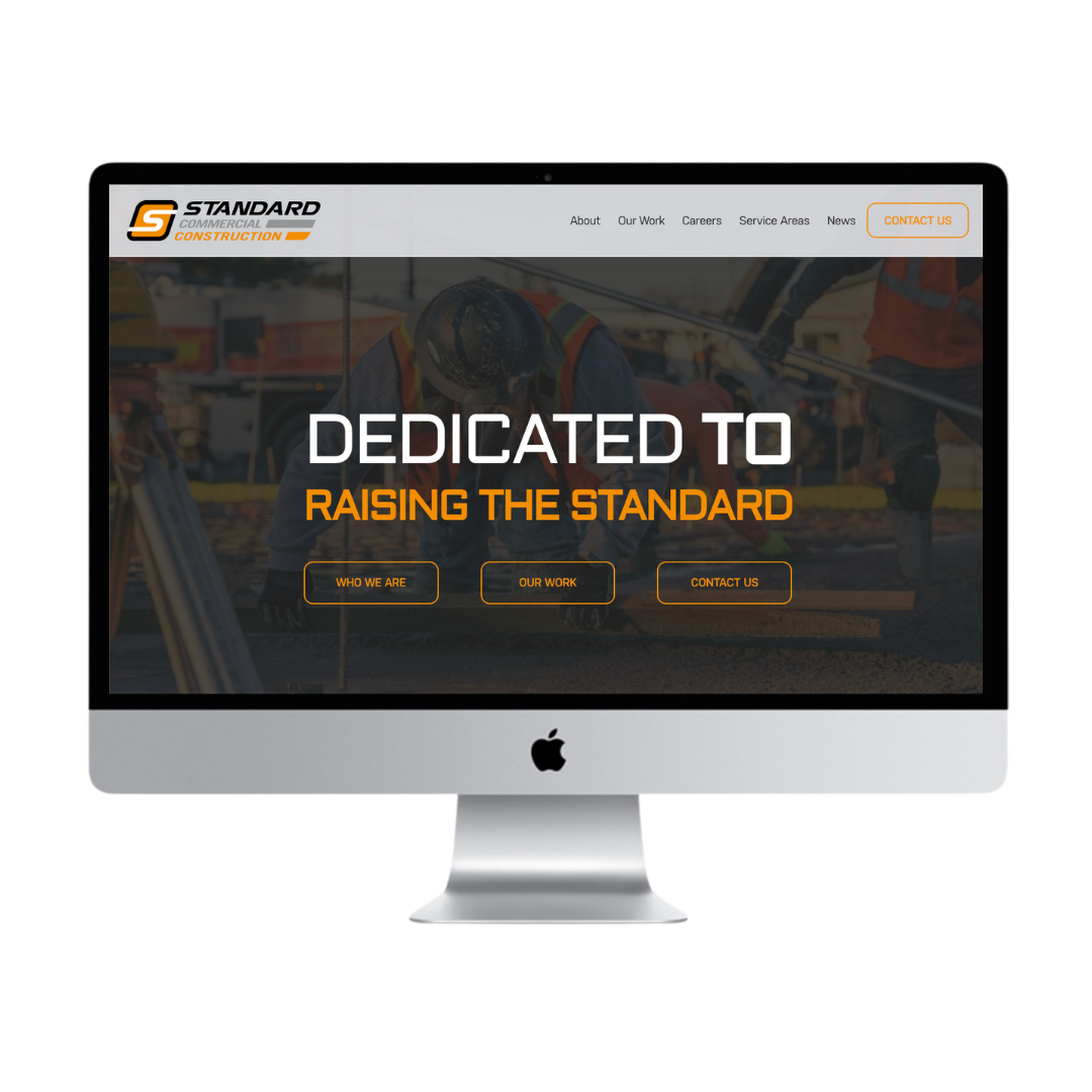 Construction company's website displayed on an iMac screen with a background image of workers in safety gear working on a construction site. Text on the screen reads "Dedicated to Raising the Standard" with navigation buttons for Who We Are, Our Work