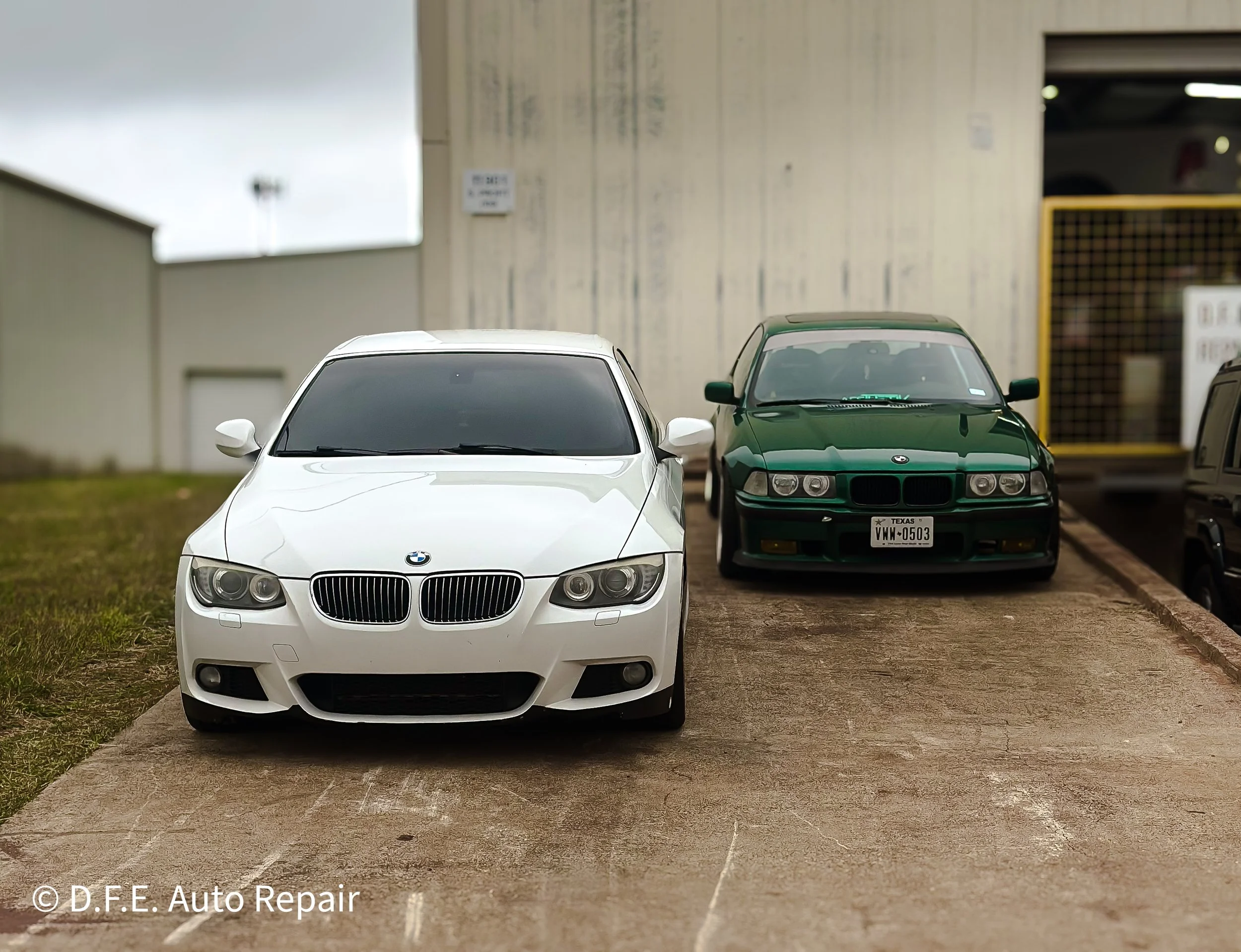 White BMW parked on the left side and green BMW parked on the right side in an outdoor lot.