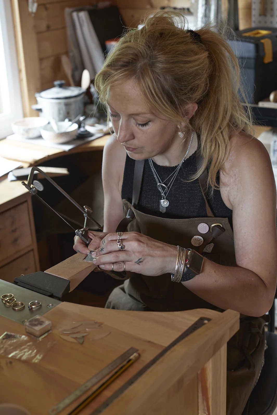 Becca Charlo working at the bench - Each piece is handcrafted from Becca's Isle of Wight studio using traditional goldsmithing techniques, from initial design through to finishing and stone setting.