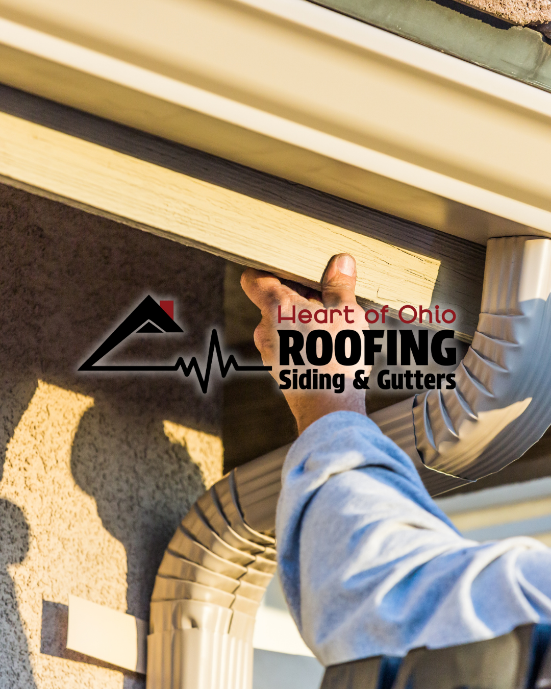 Worker installing siding or gutters on a house.