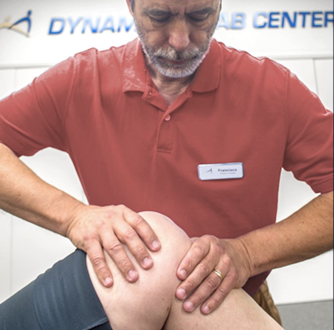 Nurse assisting an elderly man with a leg injury or exercise. 