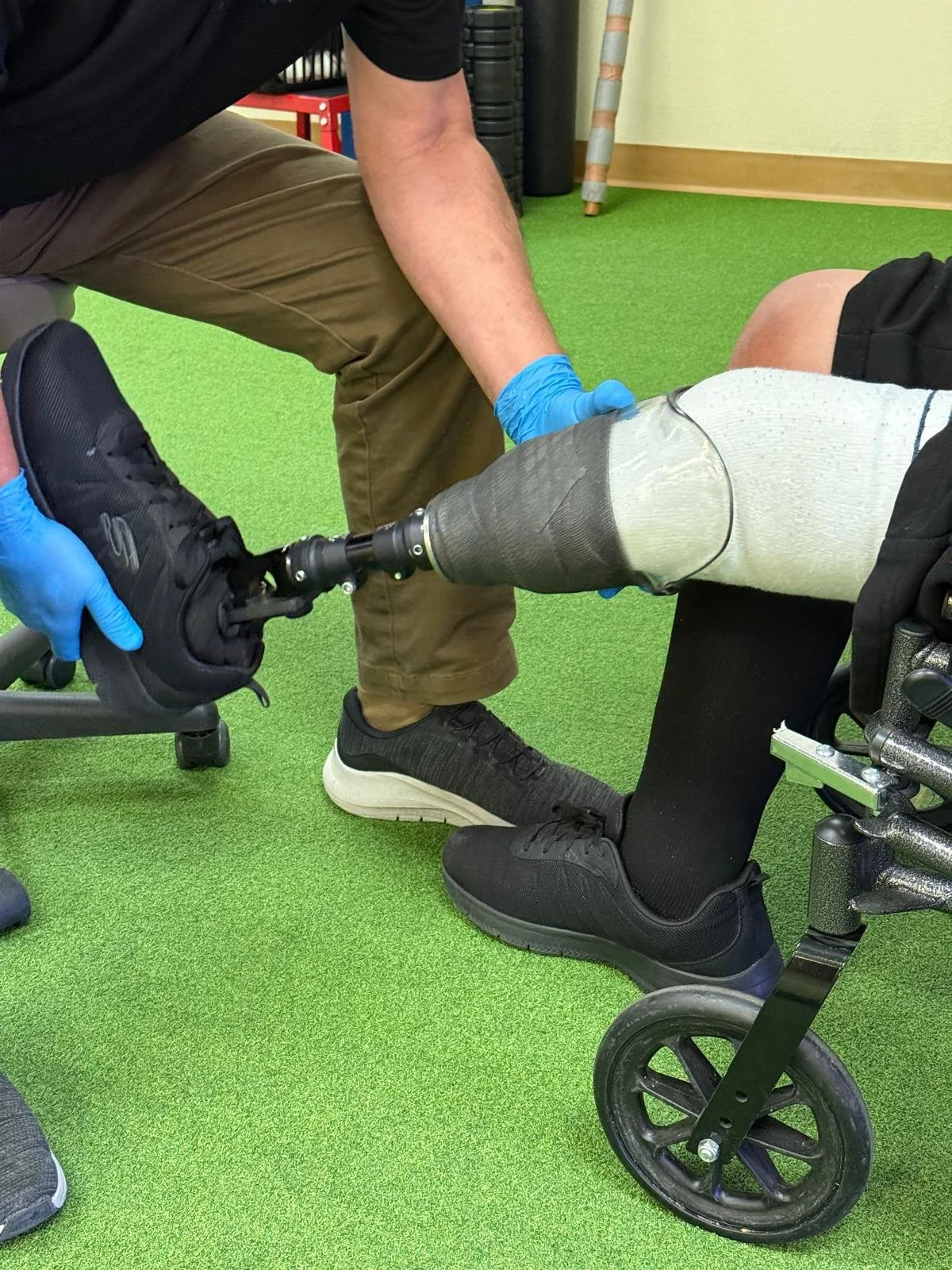 A physical therapy session using a robotic leg brace device for leg rehabilitation on a padded table.