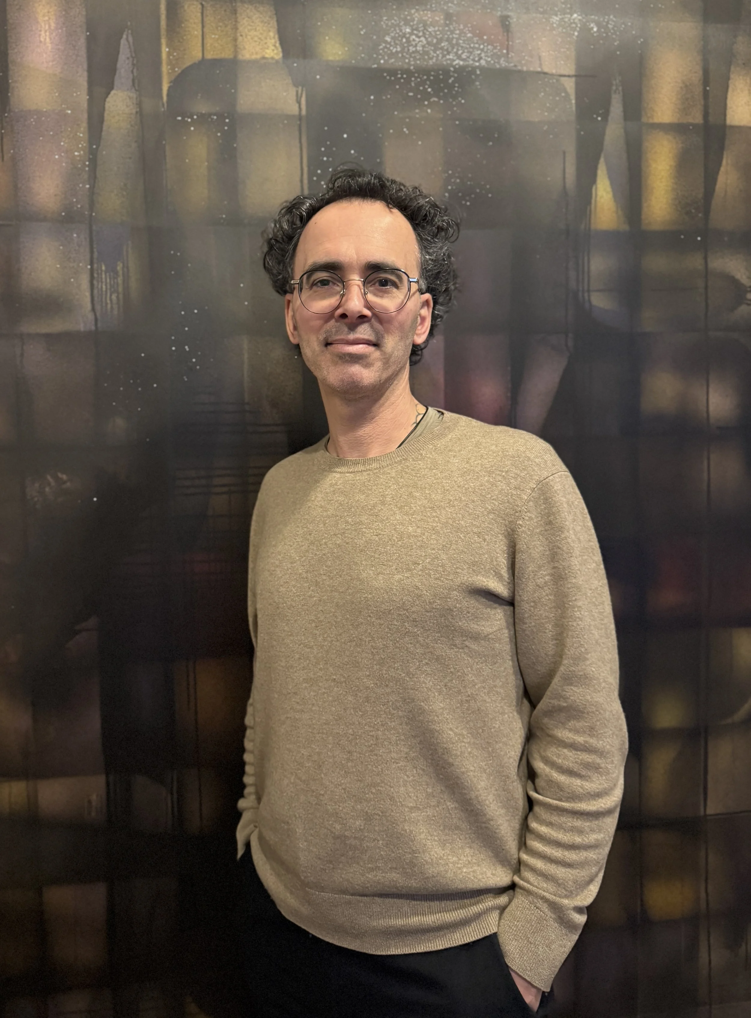 cedric legroc, photo portrait de présentation,  Clermont-Ferrand, 2026, sur fond peinture abstraite floatting cross noir avec paillettes, acrylique sur toile