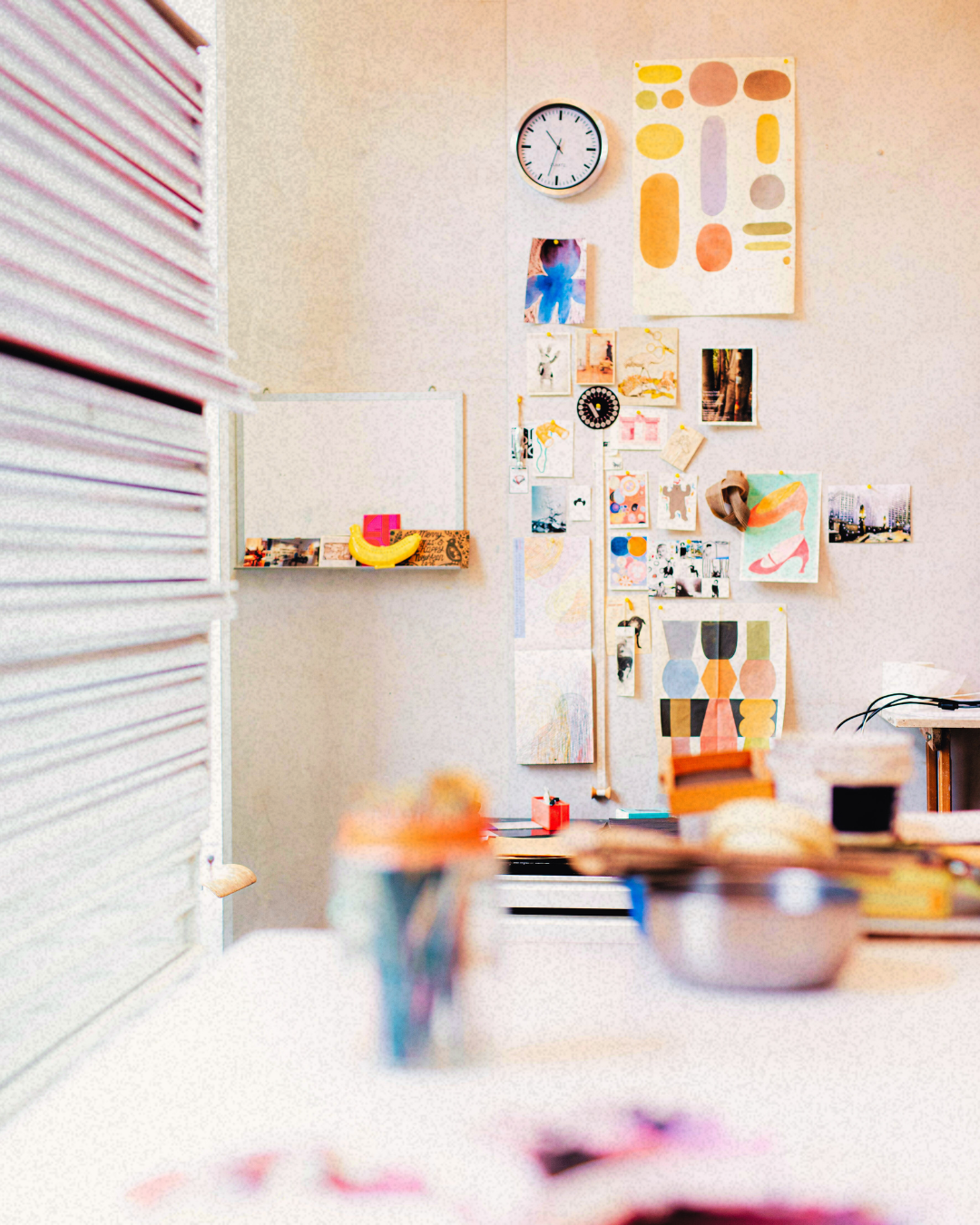 Moodboard of various images taped to a wall.