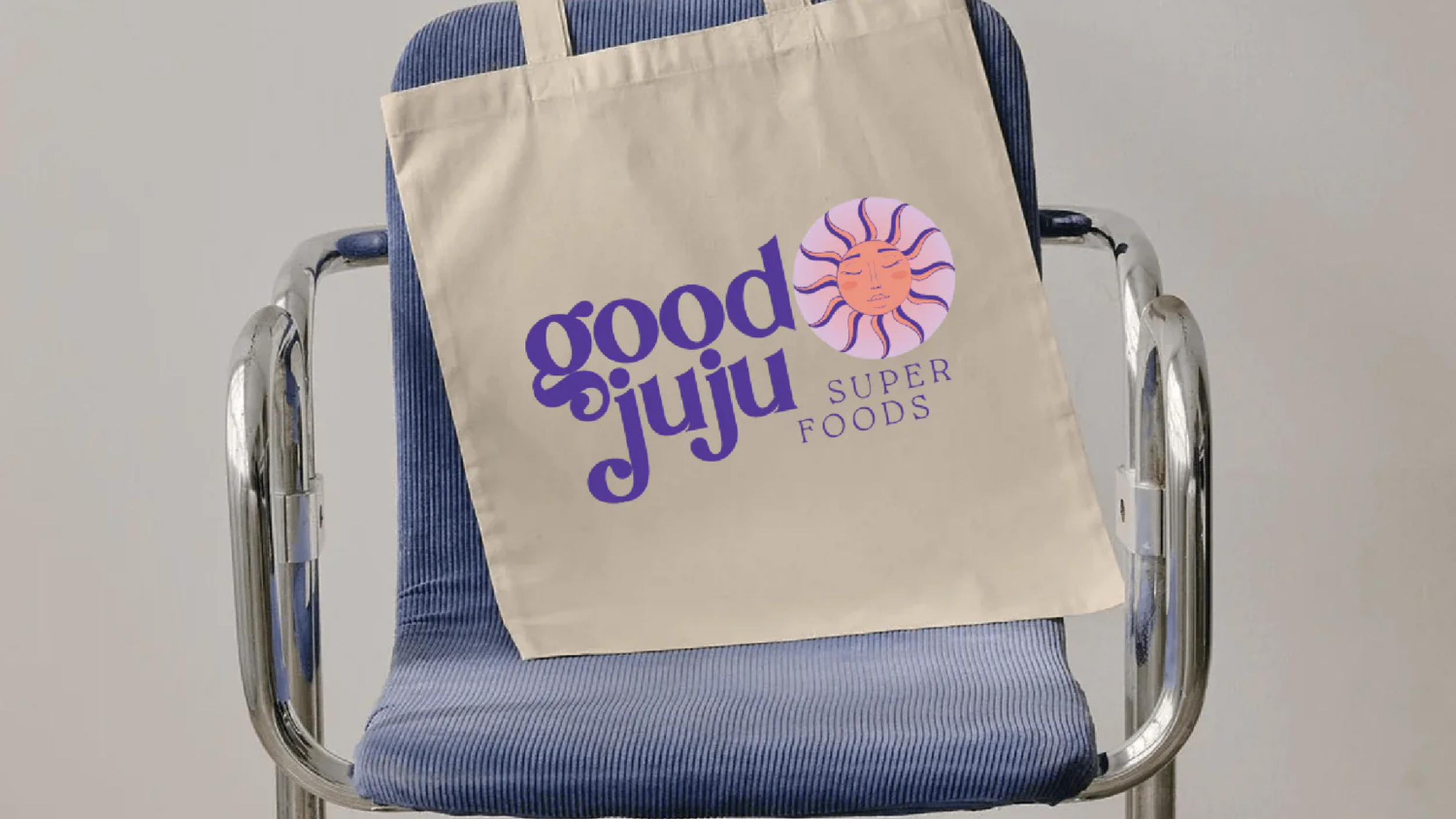 Good JuJu Superfoods logo of fun font and a funky sun on a tote bag.