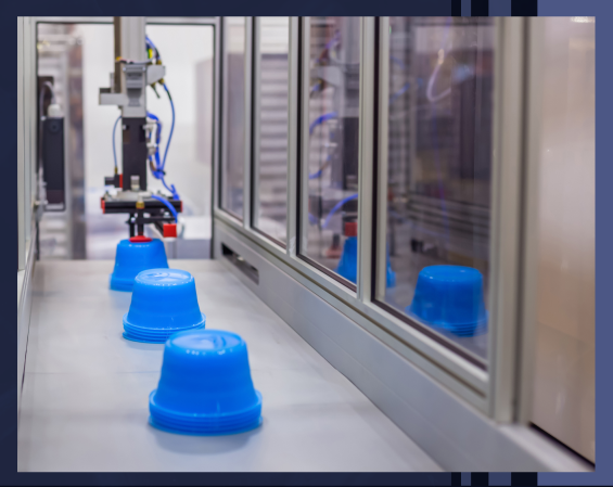 Blue plastic cups on an automated production line in a factory.