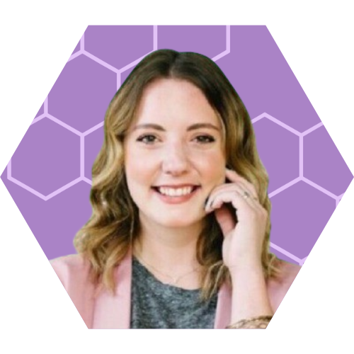 A smiling woman with shoulder-length wavy hair, wearing a pink blazer and gray top, against a purple background with hexagon patterns.