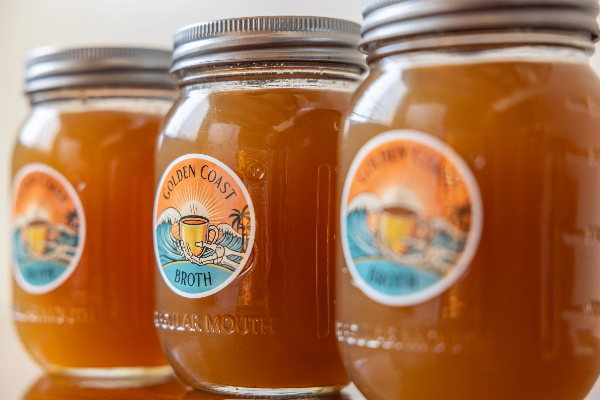 16oz glass jars of Golden Coast organic bone broth.