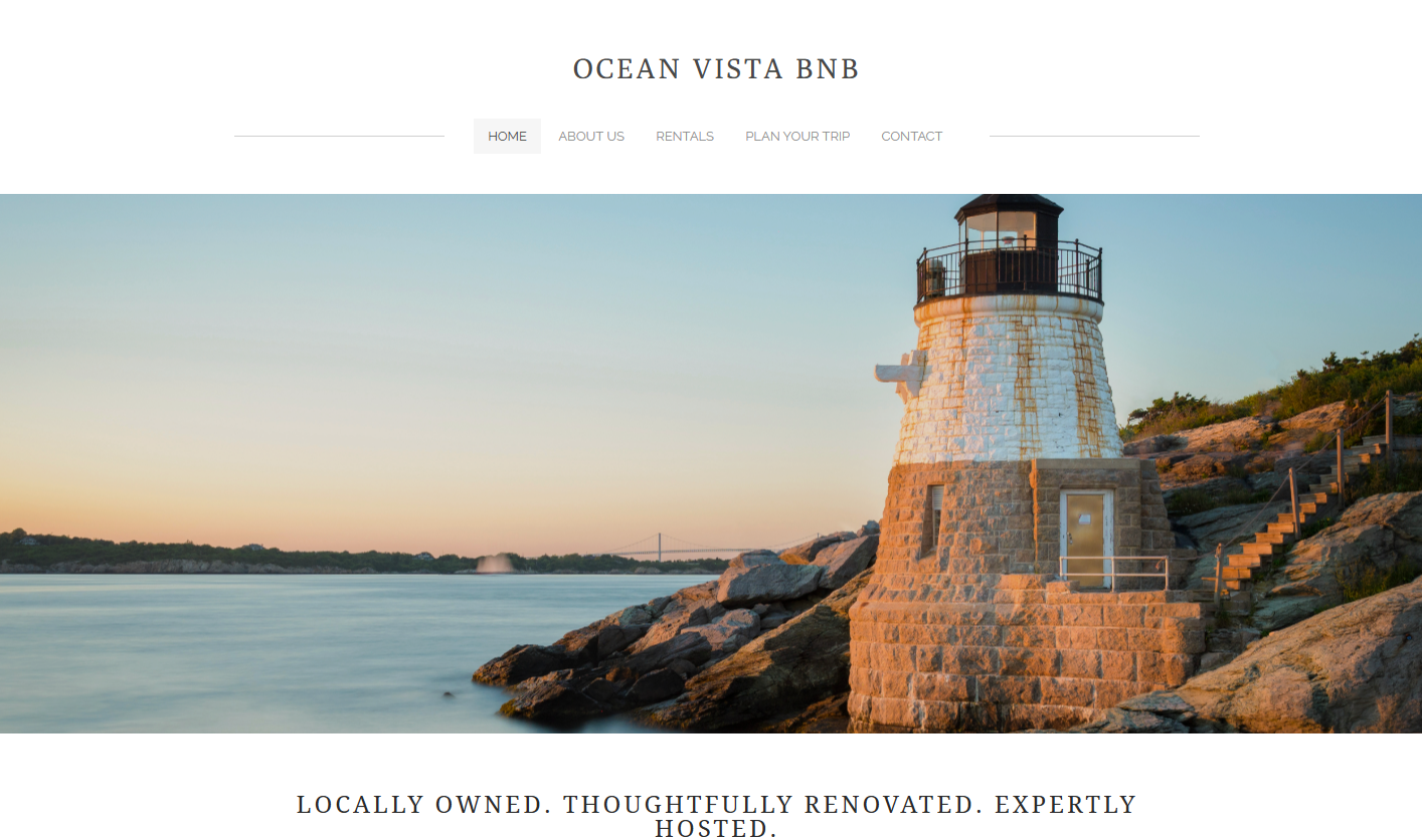 Lighthouse on rocky shoreline during sunset with bridge in the background