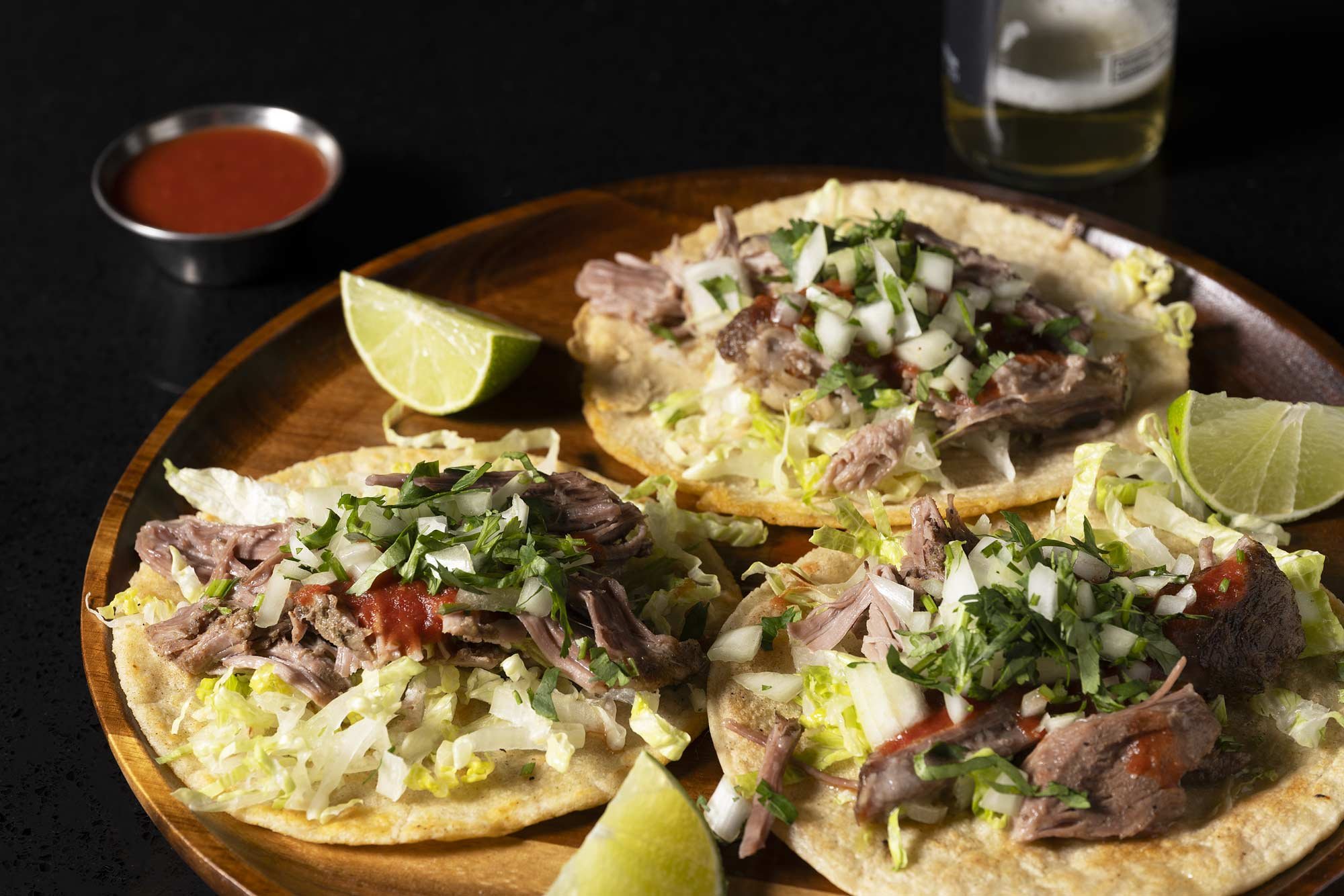 a plate of 3 carnitas tacos