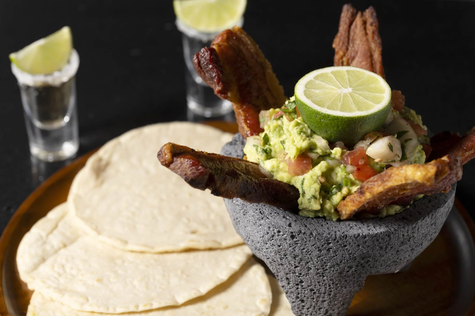 chicharrones with guacamole in a molcajete and tortillas