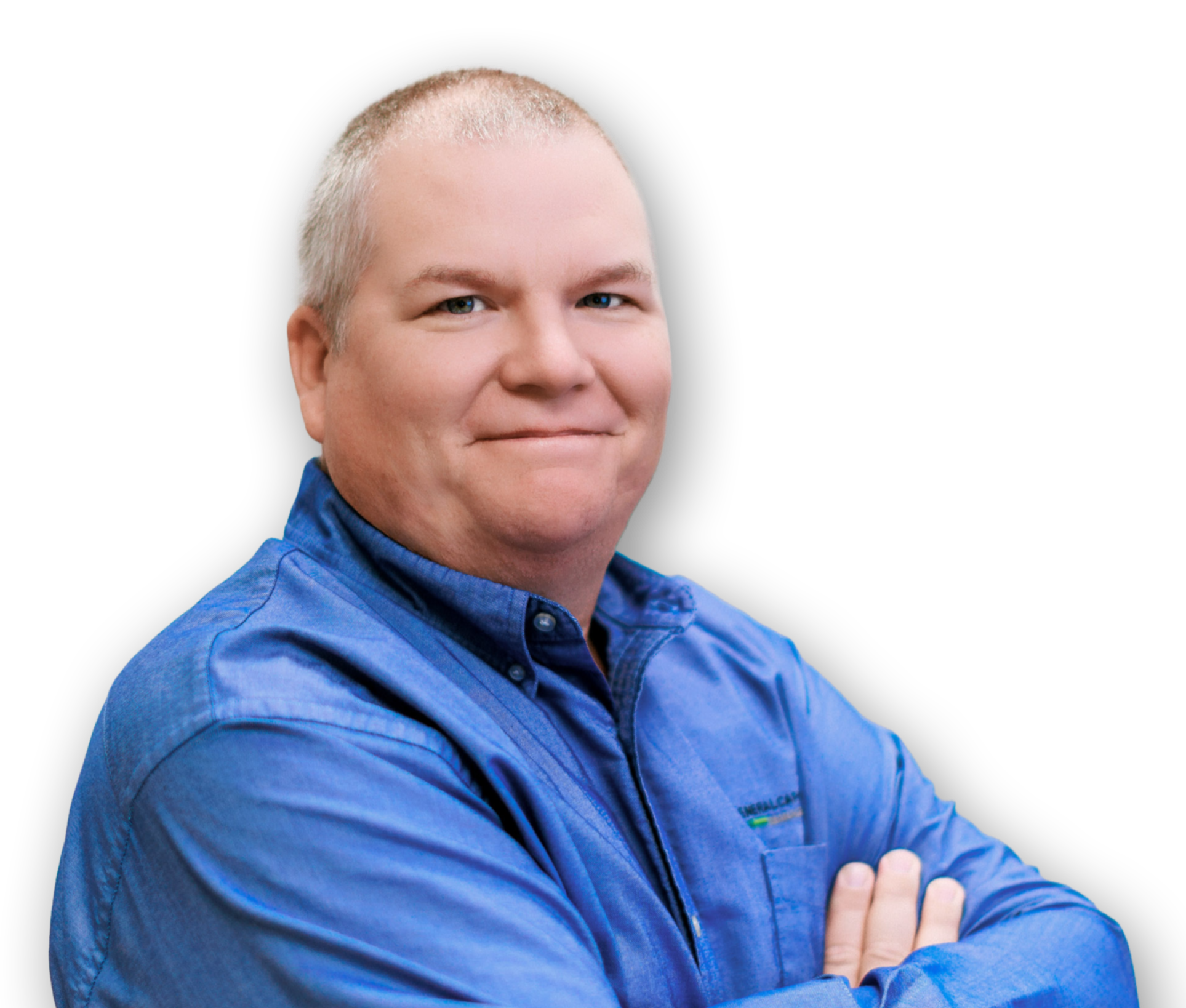 A person wearing a blue jacket with a logo, crossing their arms and smiling, against a black background.