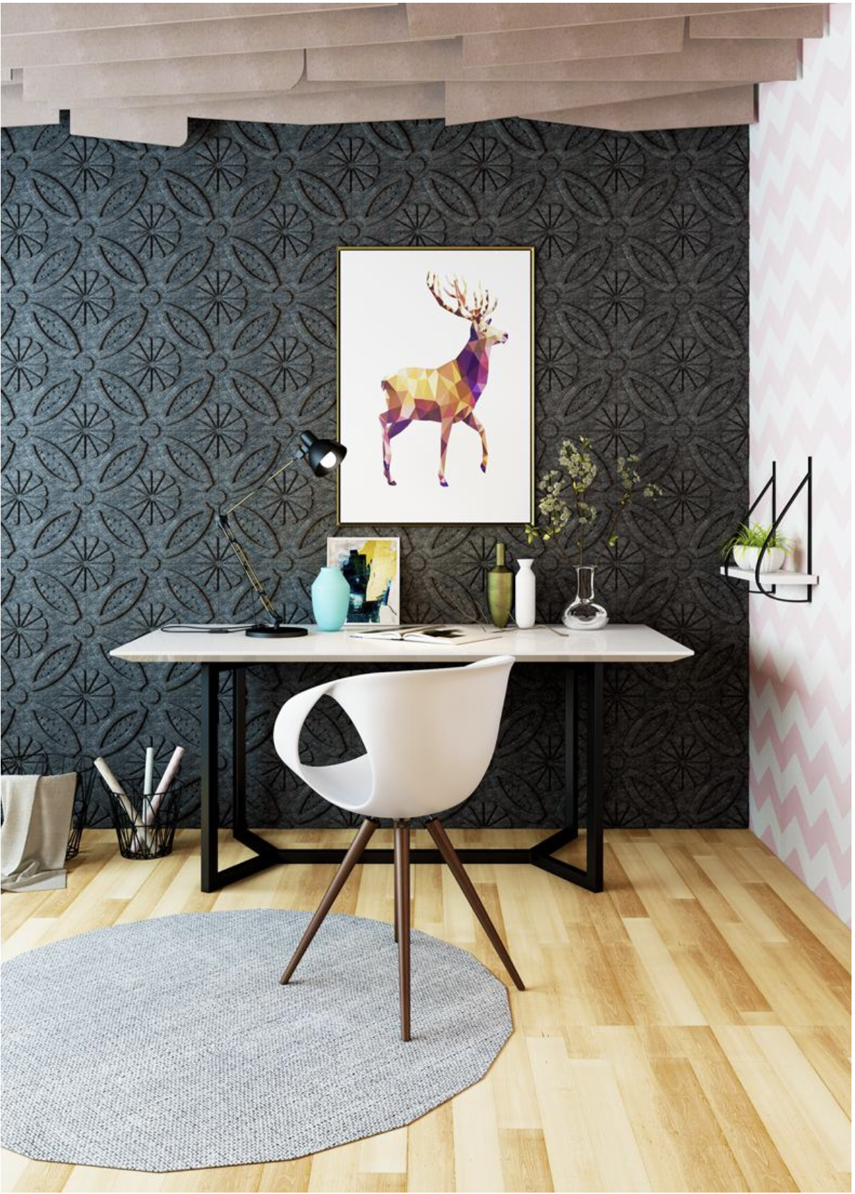 Modern office desk with a white chair, decorative books and vases, black desk lamp, and framed colorful deer art on a dark patterned wall, with a light pink and white chevron wall and small indoor plant in the background.